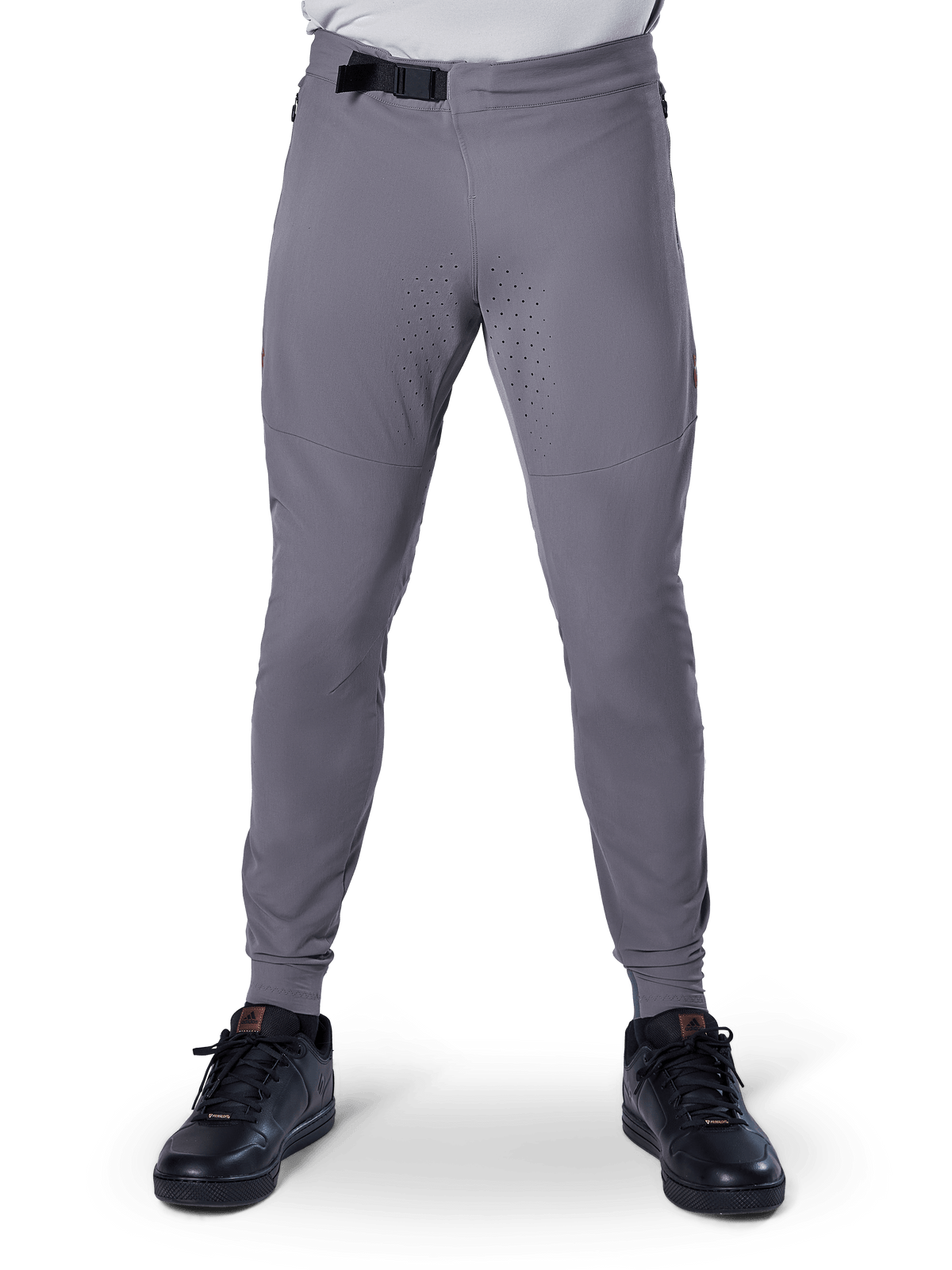 Alpinestars A-Aria Elite bukser, mountainbike-bukser, mørkegrå, med laserperforeringer på indersiden af lårene for ventilation og magnetisk spændelukning i taljen, performance-pasform med tilspidsede ben, her vist med sorte sportssko