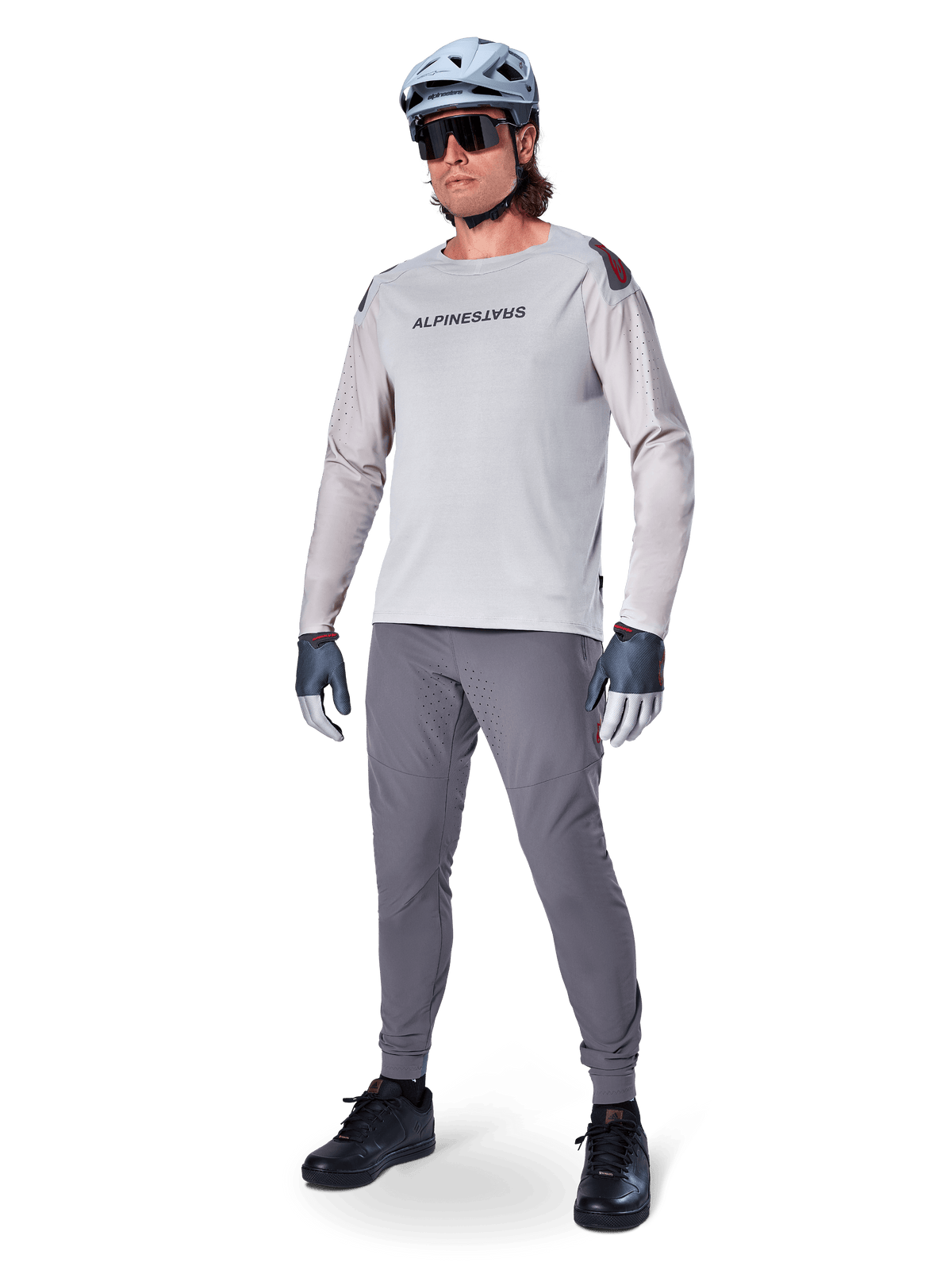 Alpinestars A-Aria Elite bukser, mørkegrå MTB-bukser, båret af en rytter med lysegrå langærmet jersey og grå hjelm, med laserskåret ventilation på lårene og en tætsiddende performance-pasform til mountainbike.