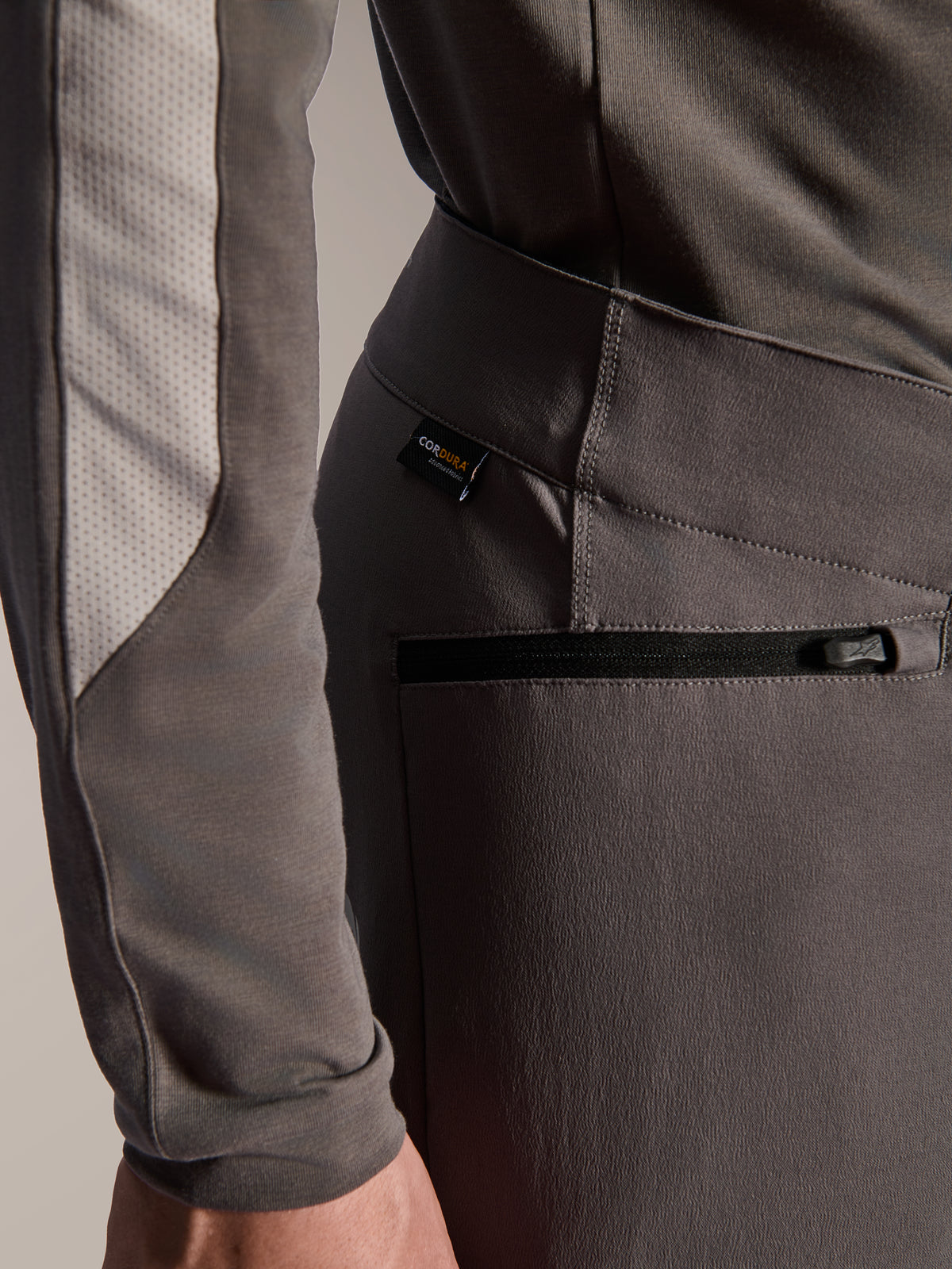Alpinestars A-Dura Elite bukser, mørkegrå mountainbike-bukser, nærbillede af sidelomme med lynlås og Cordura-stofmærke, slidstærkt tekstil med 4-vejs stretch til off-road kørsel