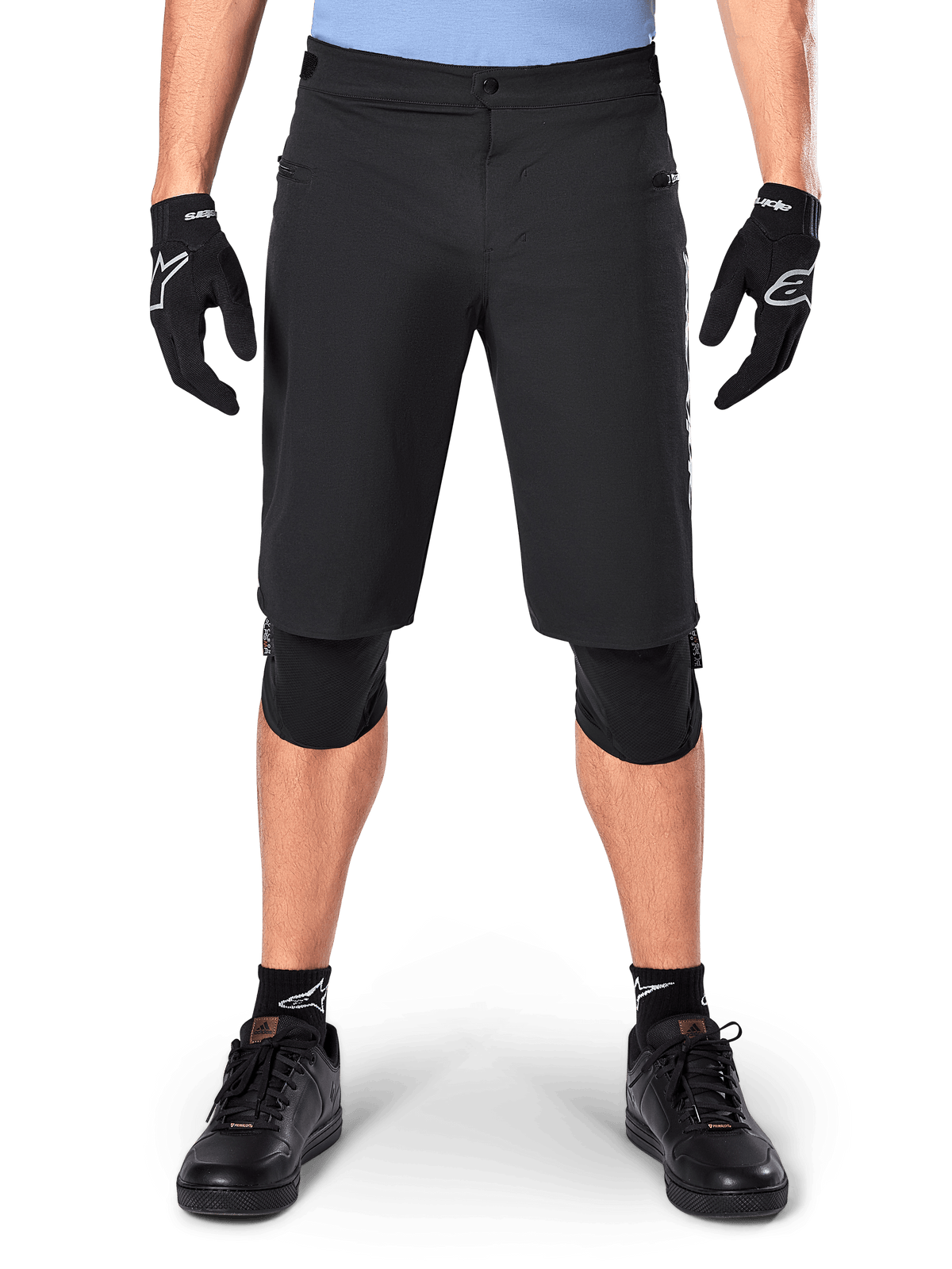 Alpinestars A-Dura Elite Shorts, sorte mountainbike-shorts, bæres af en rytter med sorte handsker og knæbeskyttere, med trykknaplukning foran og lynlåslommer, slidstærkt Cordura-materiale til off-road cykling