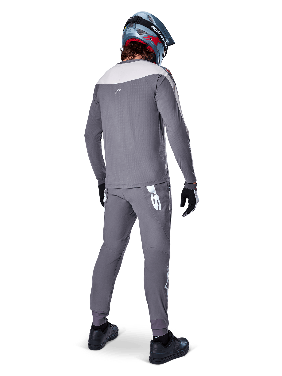 Alpinestars A-Supra Race bukser, mørkegrå, mountainbikerytter set bagfra iført komplet racersæt, grå langærmet trøje, mørkegrå bukser med hvidt MX-inspireret logo på bagstykket, grå og blå hjelm, sorte sko, designet til MTB-ydeevne