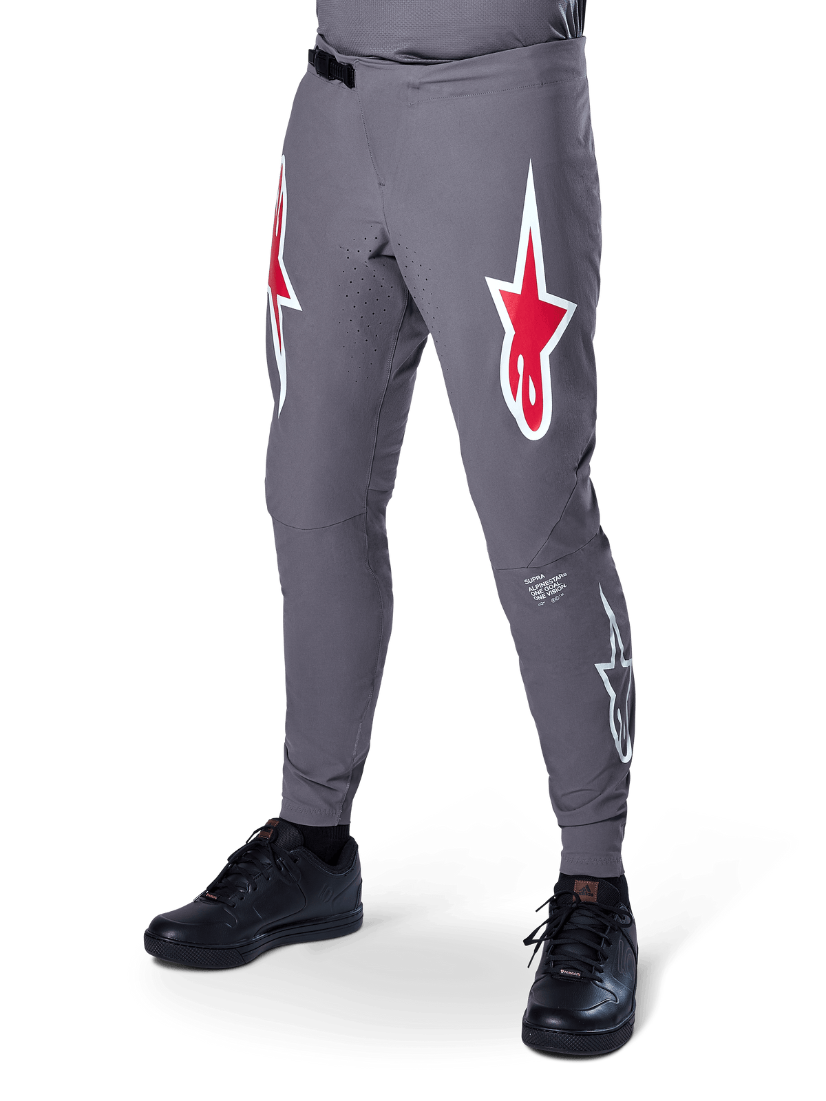 Alpinestars A-Supra Race bukser, mørkegrå mountainbike-bukser, med store røde og hvide stjernelogoer på lårene, laserperforeret ventilation og ratchet-lukning i taljen, performance pasform til downhill- og enduro-løb