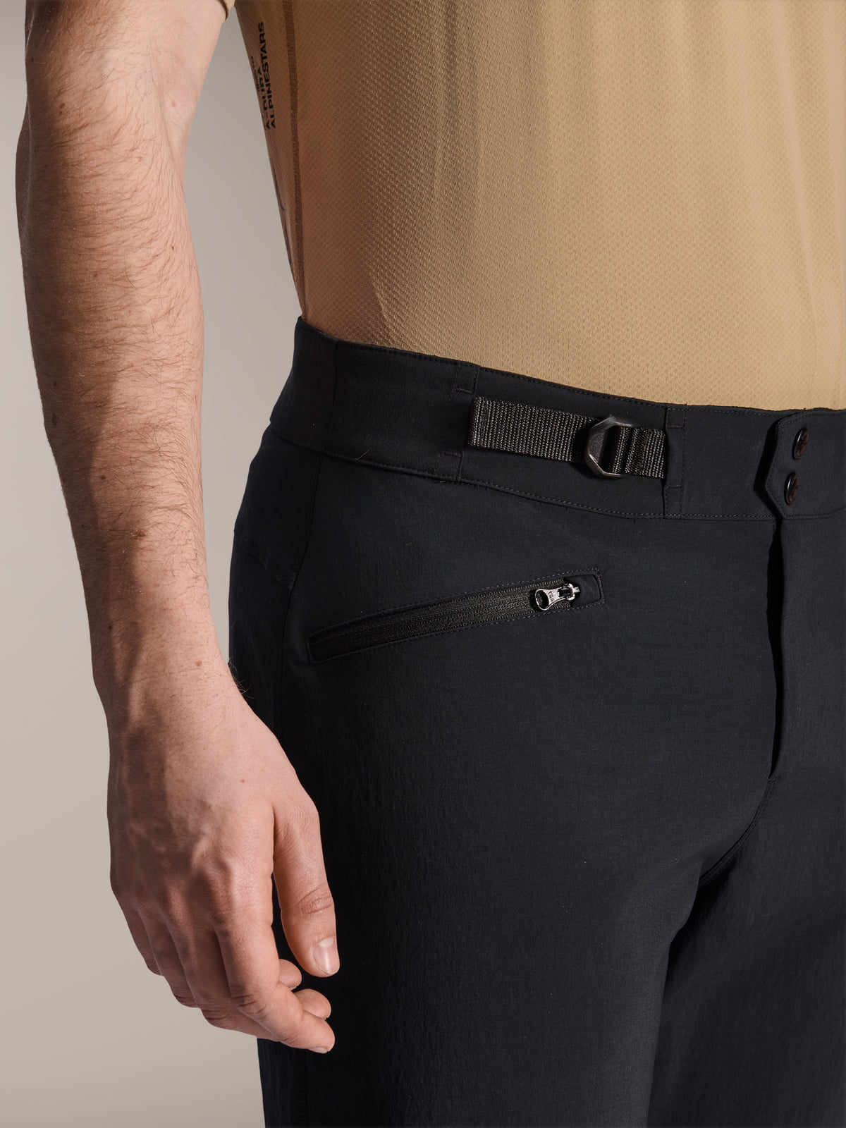 Alpinestars A-Dura shorts, sorte MTB-shorts, nærbillede der viser lynlåslomme og justerbar taljerem i siden, dobbelt tryknapslukning, slidstærkt materiale til mountainbike