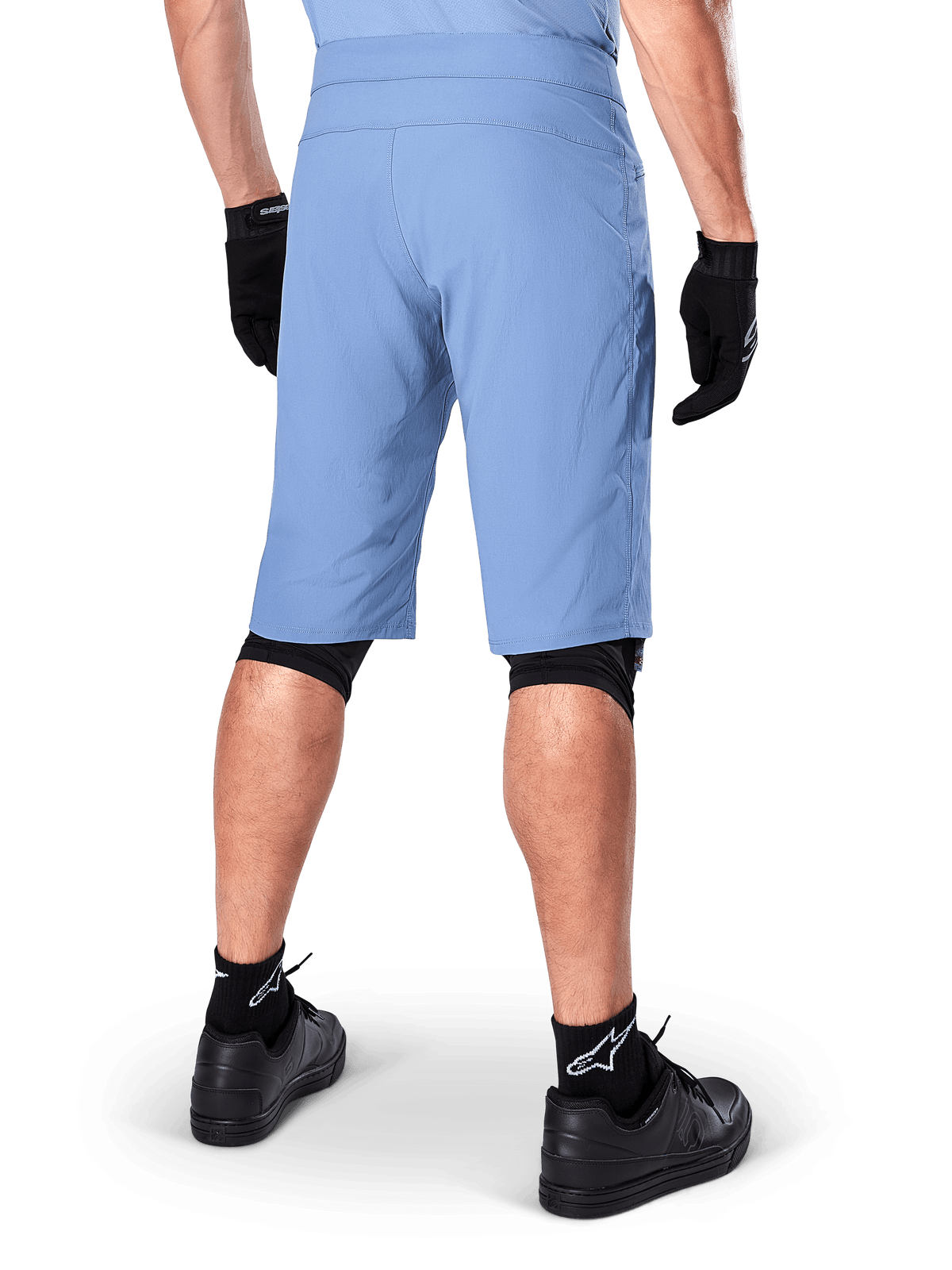 Alpinestars A-Dura Shorts, Infinity Blue mountainbike-shorts, set bagfra, kombineret med sorte handsker, knæbeskyttere og sorte sokker med hvidt stjerne-logo, slidstærkt strækmateriale til off-road cykling