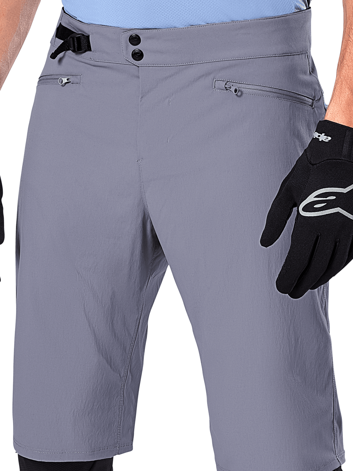 Alpinestars A-Dura Shorts, MTB-shorts, mørkegrå, nærbillede af taljen med dobbelt trykknaplukning, sidejustering af taljen og lynlåslommer, kombineret med sorte cykelhandsker, holdbart mountainbike-tøj