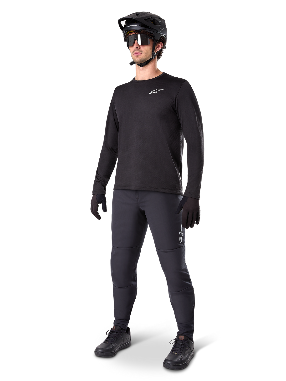 Model iført Alpinestars A-Dura Thermal Jersey, sort langærmet MTB-trøje, sort mountainbike-hjelm, solbriller og mørkegrå bukser, med et lille hvidt logo på brystet, isoleret fleece-konstruktion til kørsel i koldt vejr