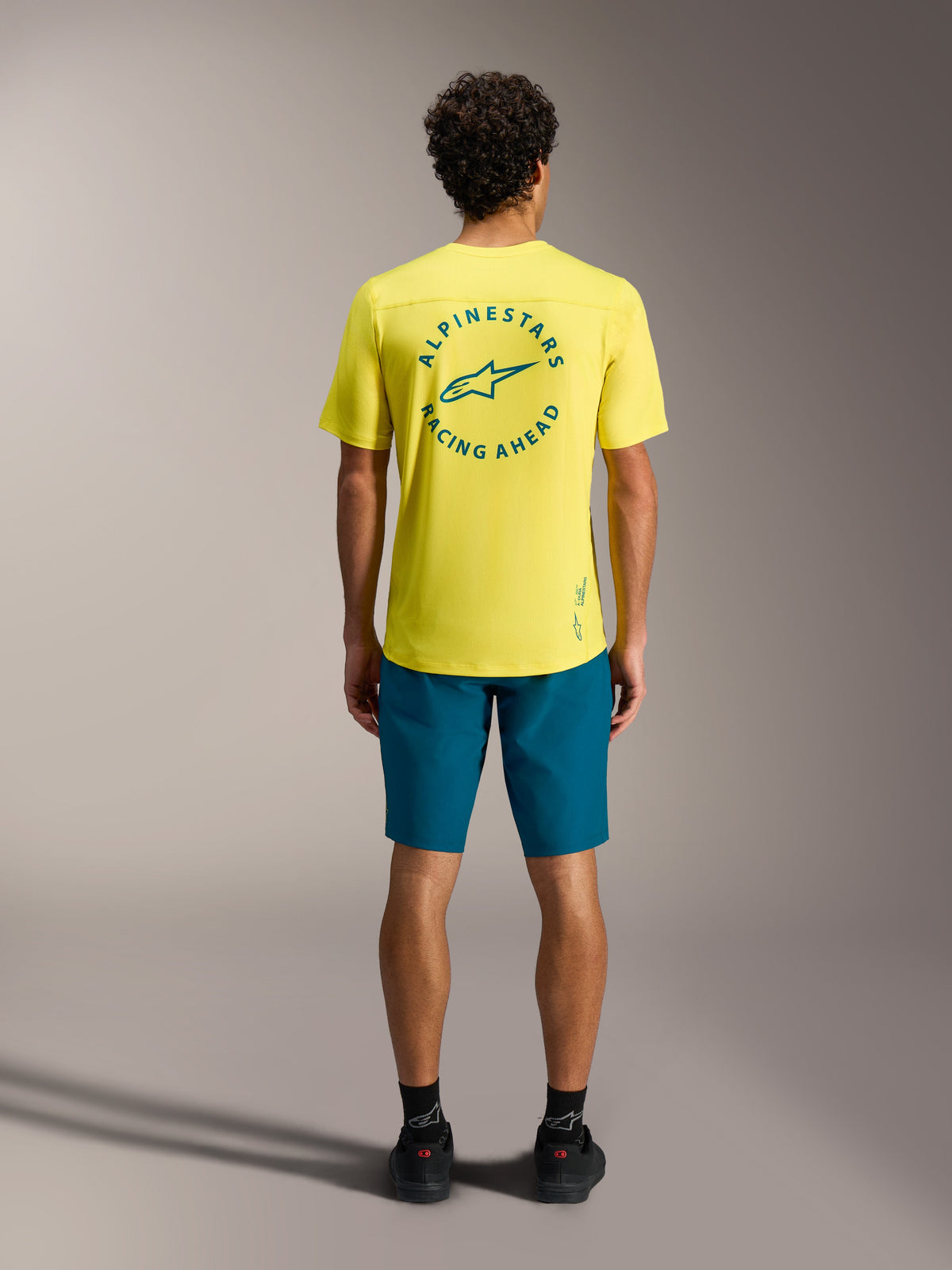 Gul A-Dura Air SS-trøje med blågrønt logo på ryggen og blågrønne A-Dura Ride Shorts, professionelt MTB-cykeltøj.