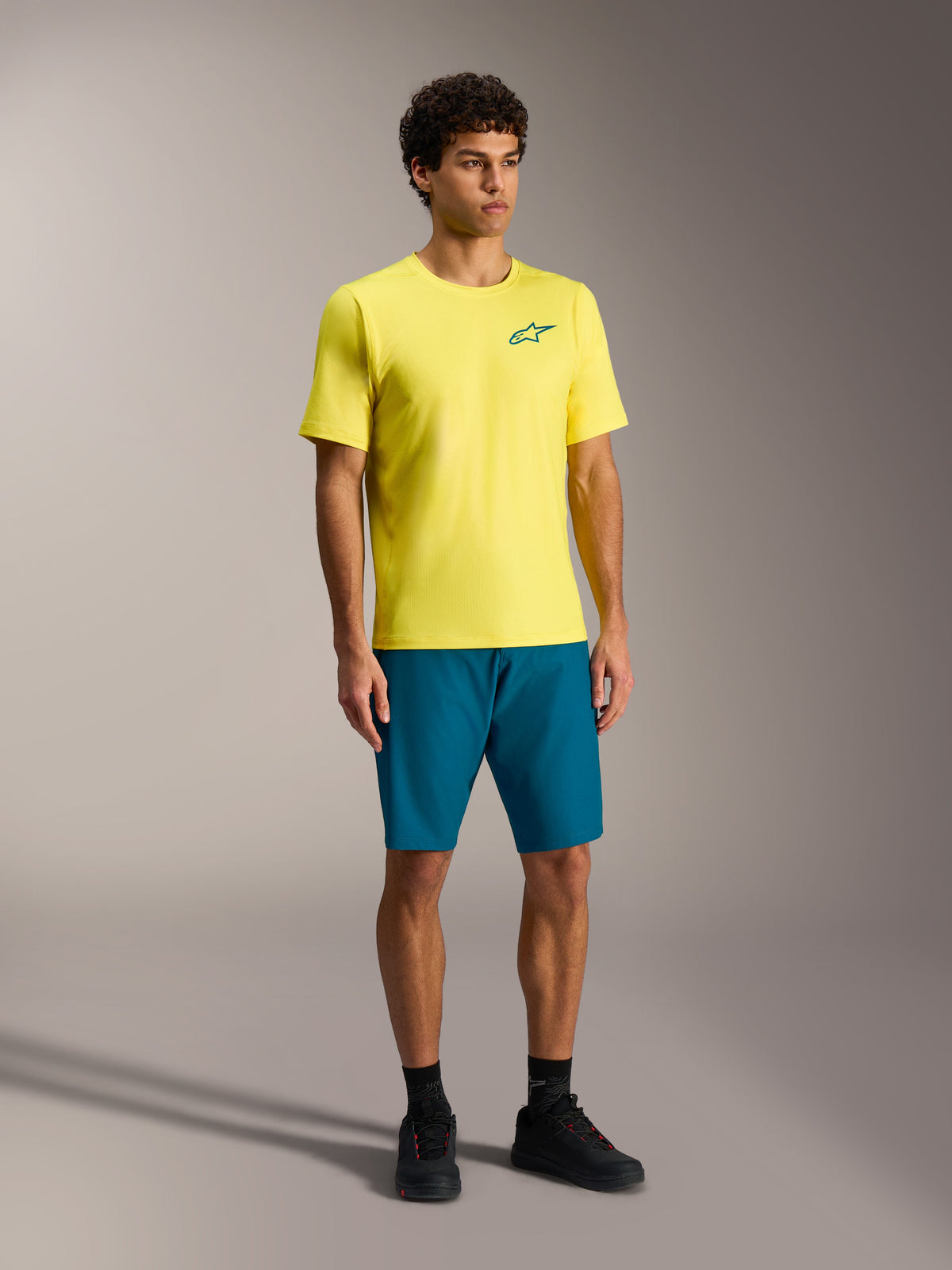 Alpinestars A-Dura Ride shorts i blågrøn og gul jersey, slidstærkt performance mountainbike-tøj til mænd.