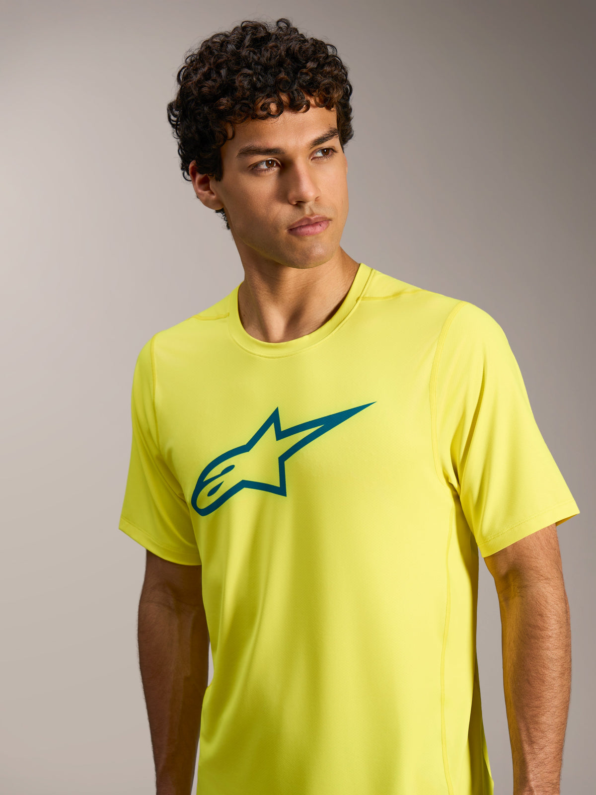 Alpinestars A-Dura Ride kortærmet jersey i neongul med blågrønt Astars-logo på brystet, performance MTB-cykeltøj