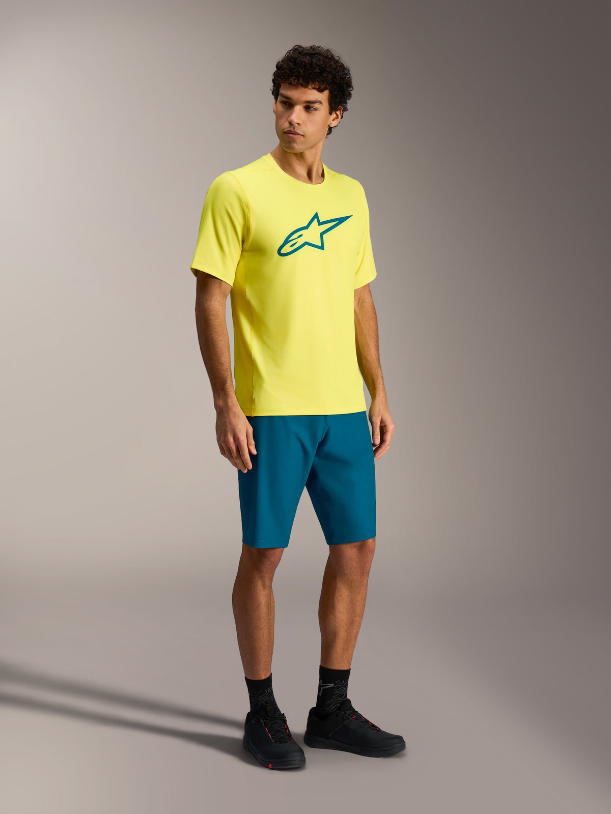 Alpinestars A-Dura Ride kortærmet trøje i Yellow Fluo med teal-logo, designet til performance MTB trail-kørsel.