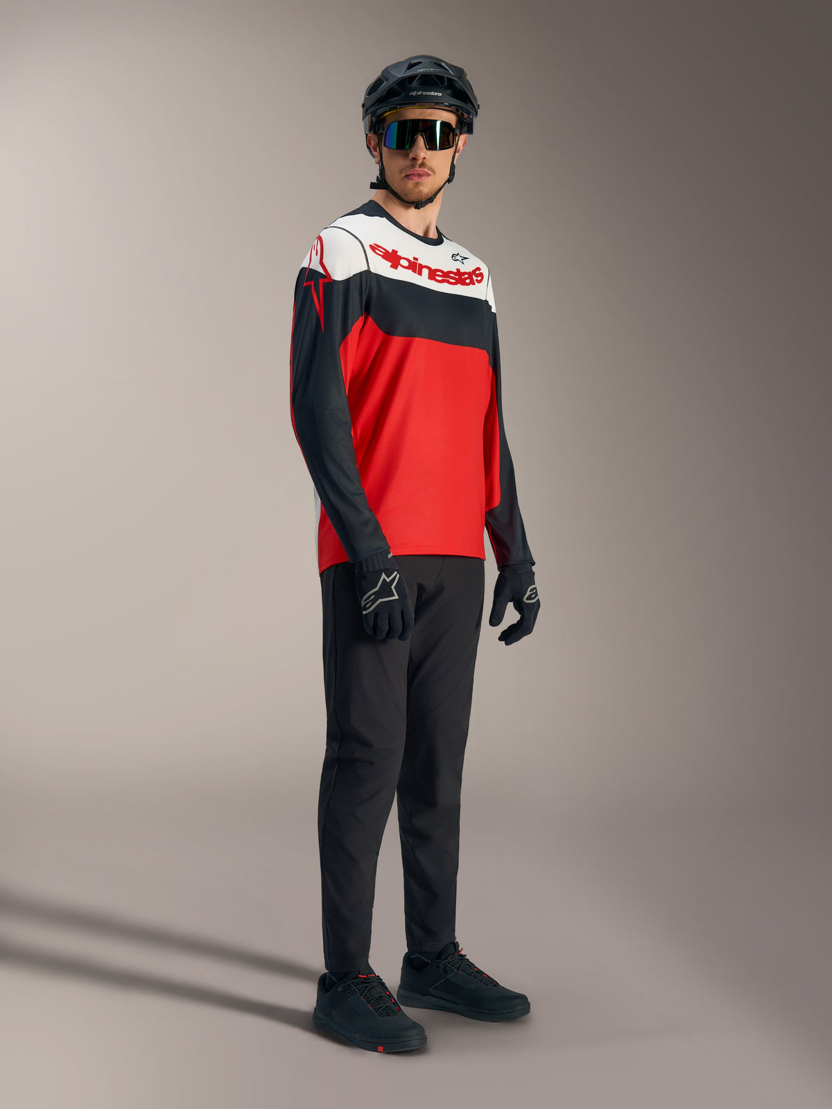 A-Dura Race langærmet trøje i rød, hvid og sort med markante logoer, stylet med professionelt mountainbike-udstyr.