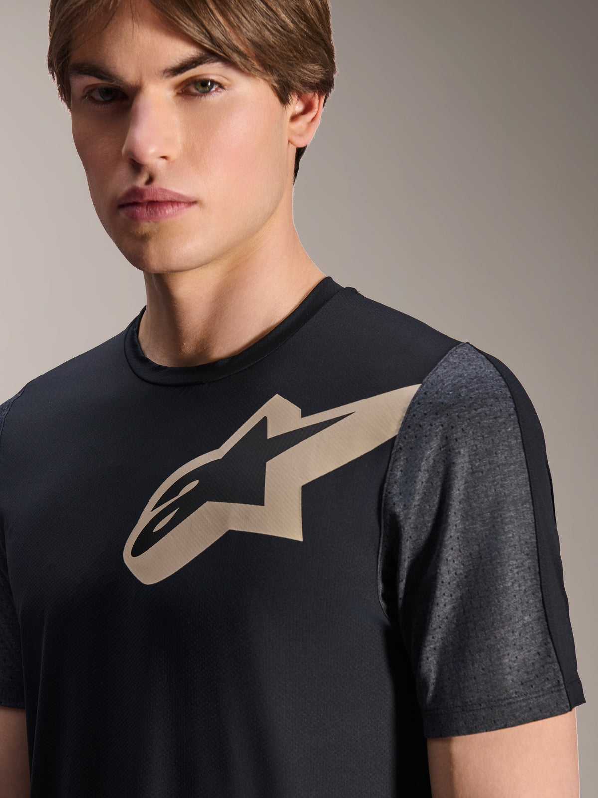 Alpinestars A-Dura Lipan kortærmet jersey, sort, med et sandfarvet Astars-logo på brystet og mørkegrå melerede perforerede ærmer, performance mountainbike-tøj