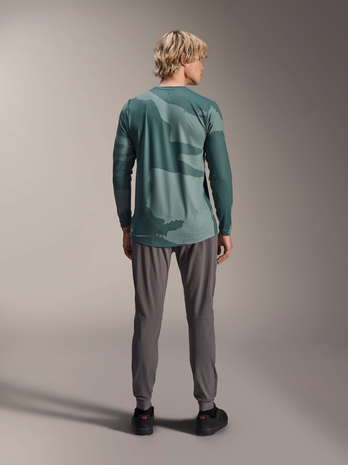 Alpinestars A-Dura Hollow Camo Jersey - Long Sleeve, Silver Pine Camo green camouflage pattern, worn by model from behind with grey technical pants, performance mountain bike apparel