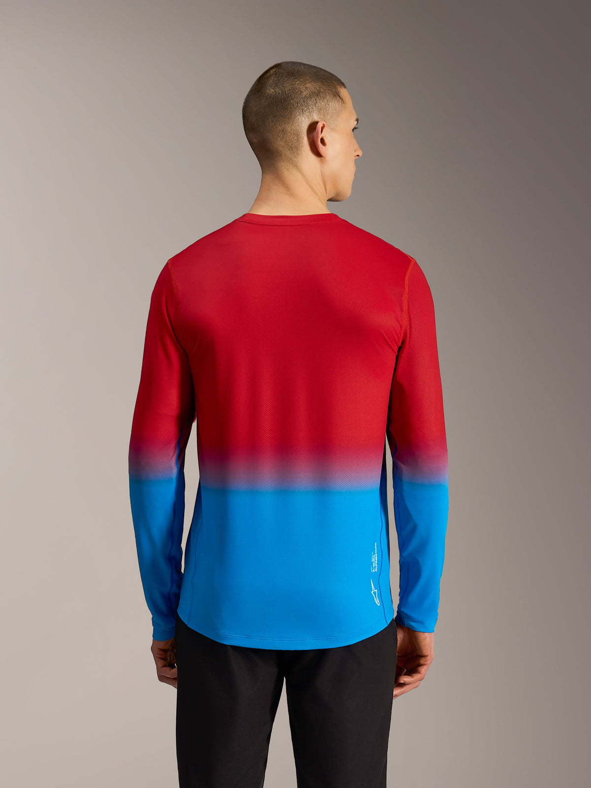 Rear view of Alpinestars A-Dura ASTARS 2.0 long-sleeve MTB jersey in Bright Red Blue gradient with a performance drop tail.