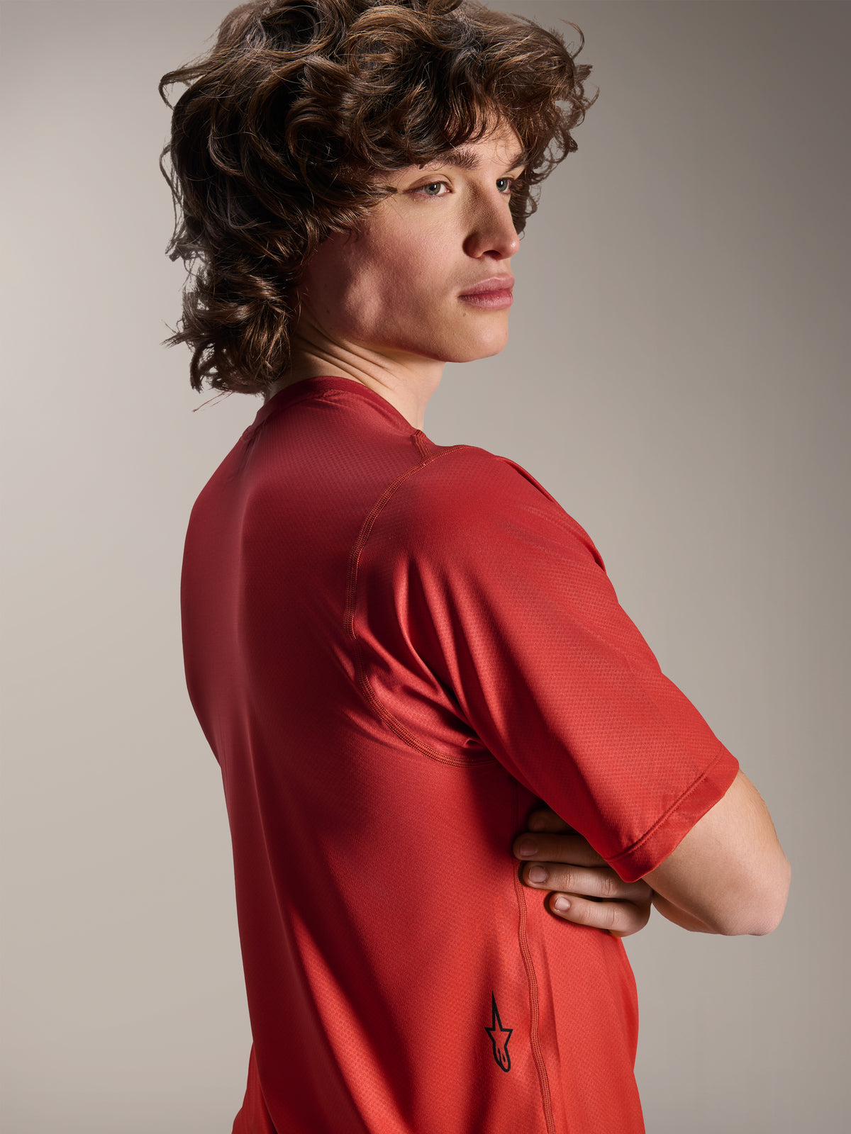 Alpinestars A-Dura Rise Jersey - Kortærmet, Spicy Orange, model set fra siden og bagfra, viser et lille sort Astars-logo på den nederste kant, letvægts tekstureret jacquard-stof til MTB-performance
