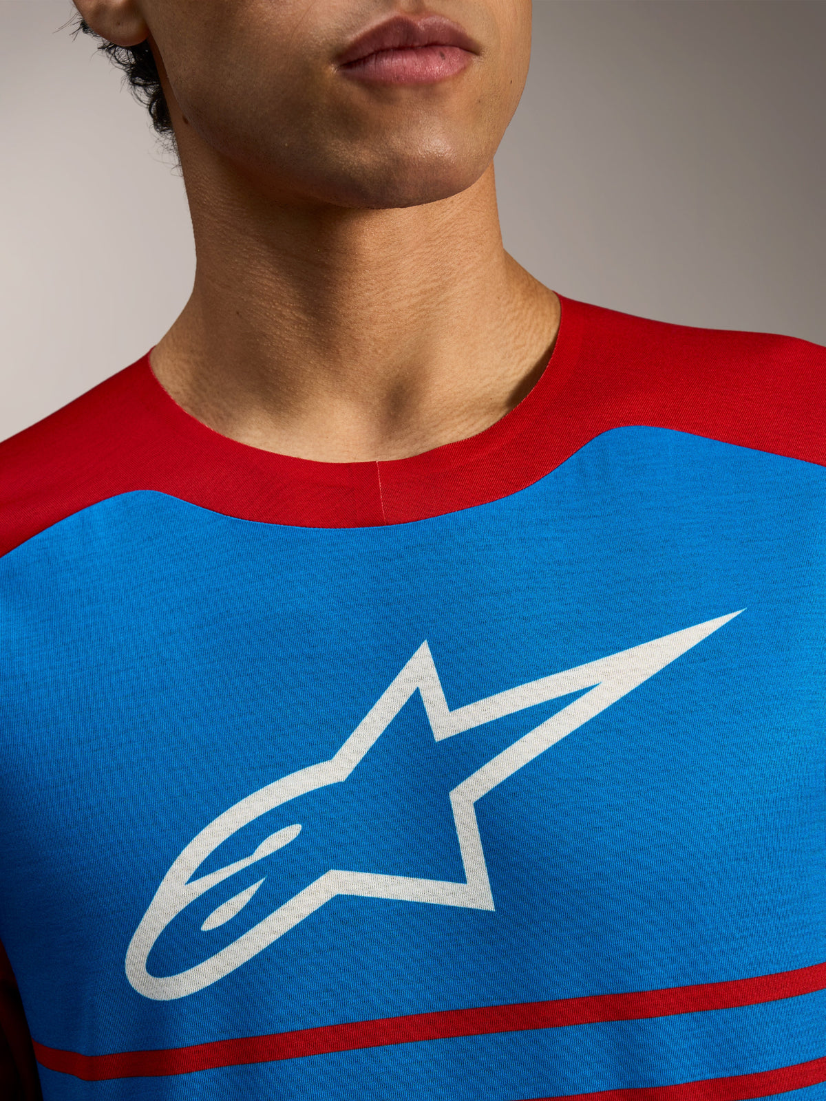 Alpinestars A-Dura Elite Trøje 2.0, blå og rød MTB-trøje med hvidt stjerne-logo på brystet, i let og åndbart materiale.