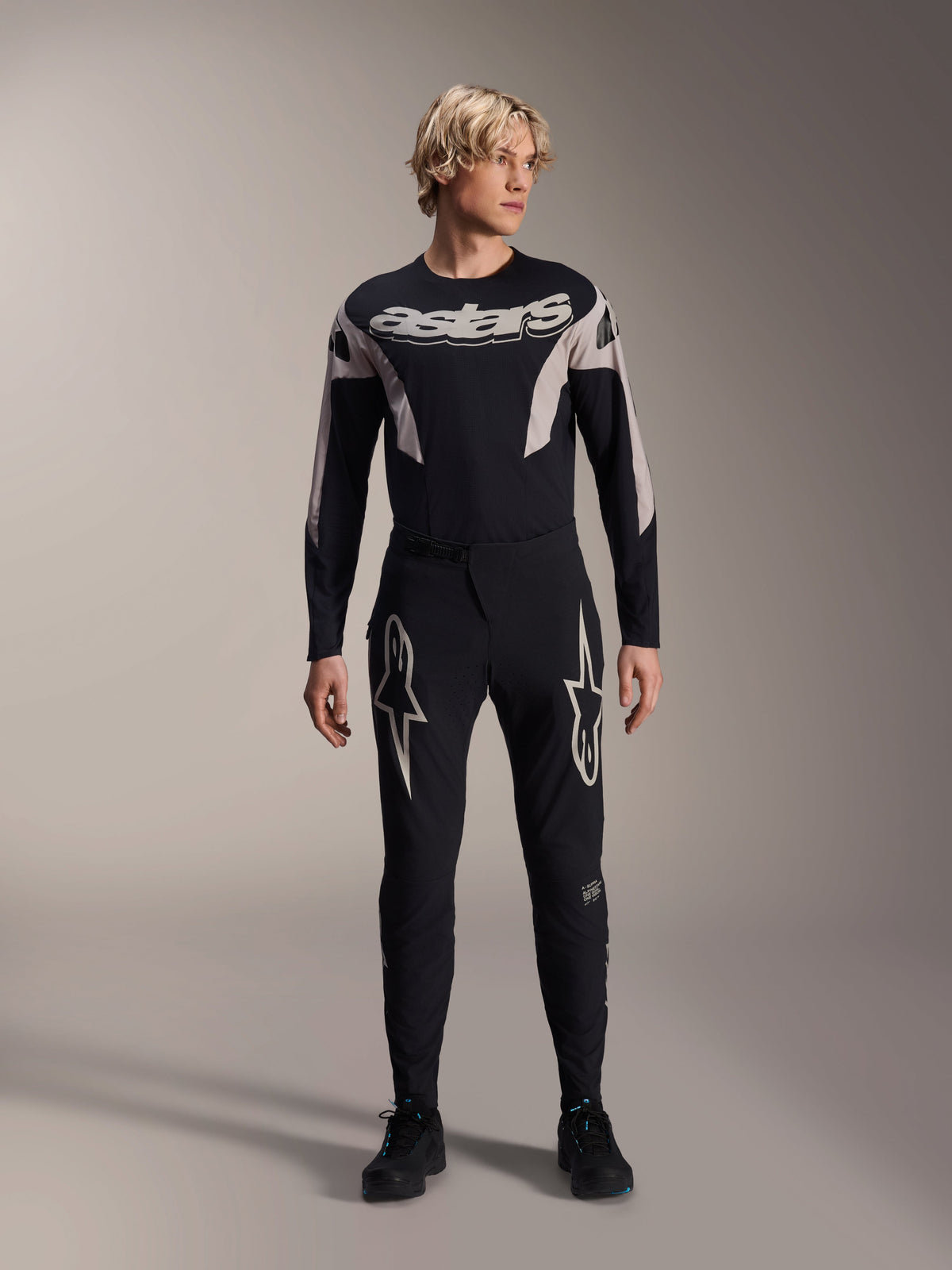 Alpinestars A-Supra Melt trøje, langærmet MTB-trøje, sort med hvidt Astars-branding over brystet, båret med matchende sorte mountainbike-bukser med stjernelogoer, strømlinet performance-cykeludstyr