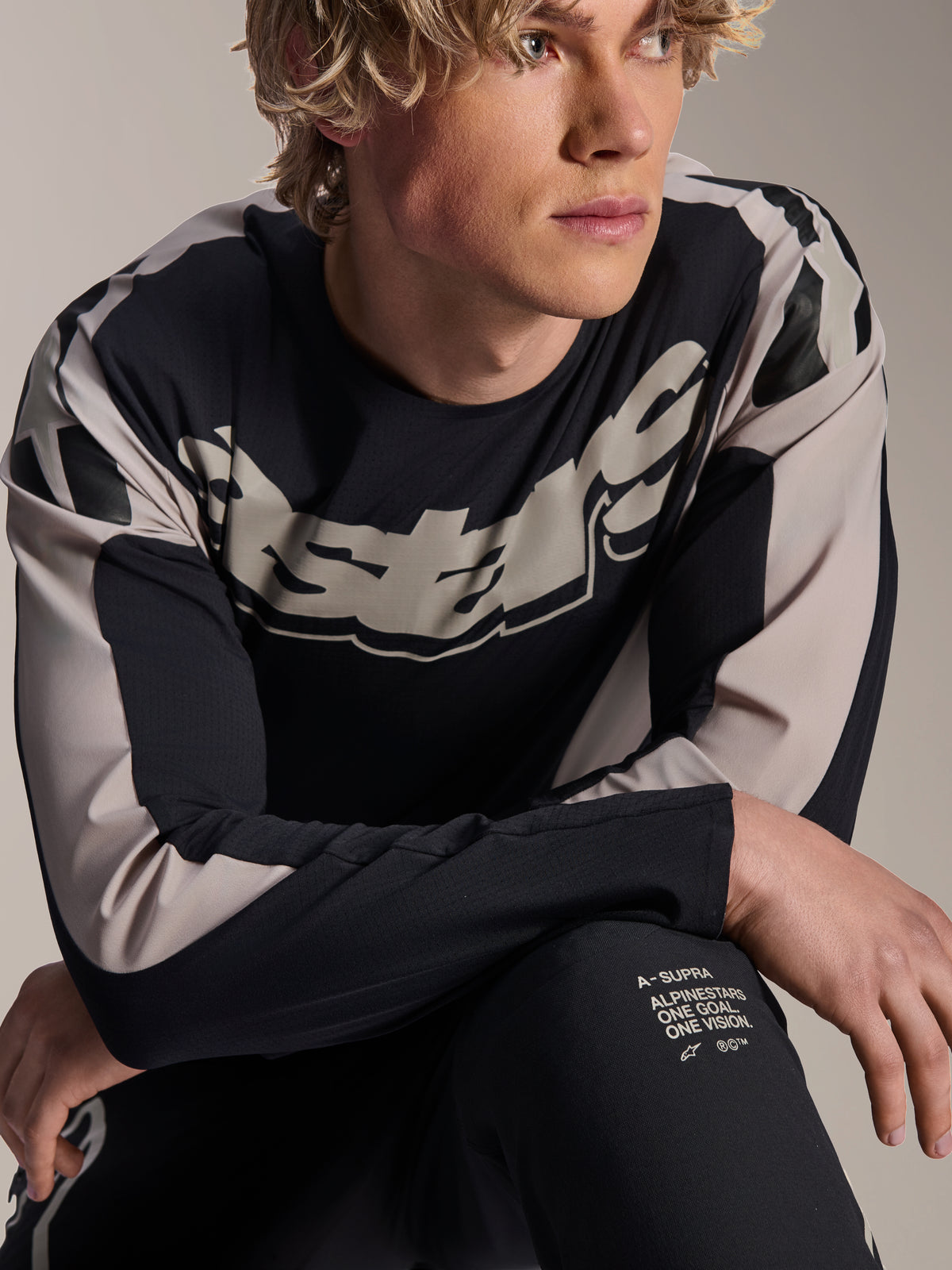 Alpinestars A-Supra Melt trøje, langærmet MTB-trøje, sort med lysegrå grafik, bæres af model, med markant logo på brystet og 'One Goal. One Vision.' branding, præstationsorienteret mountainbike-tøj