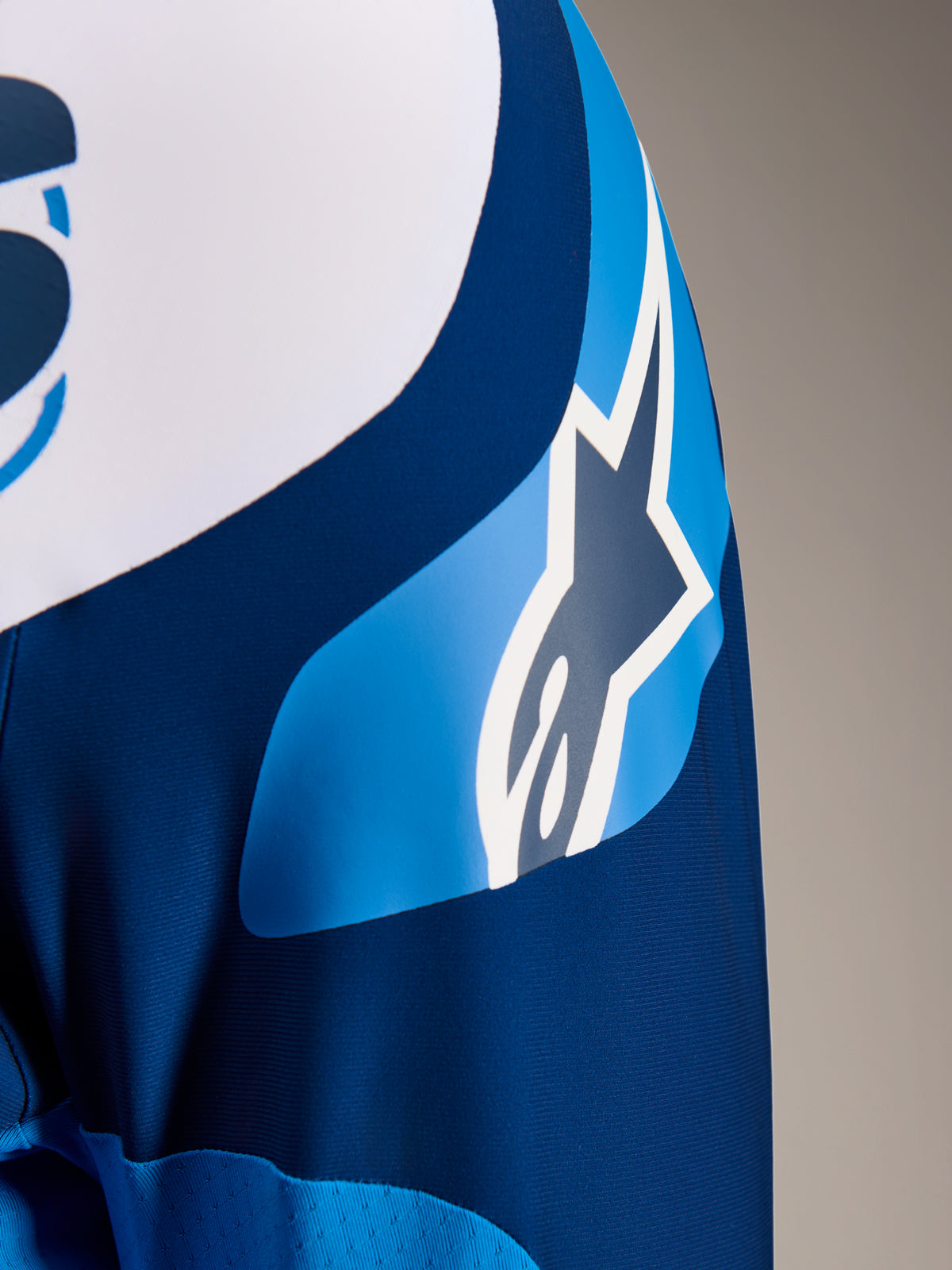 Alpinestars A-Supra Melt trøje, langærmet MTB-trøje i blå, nærbillede af ærmet med ASTARS-logografik og mikroperforeret stof til ventilation