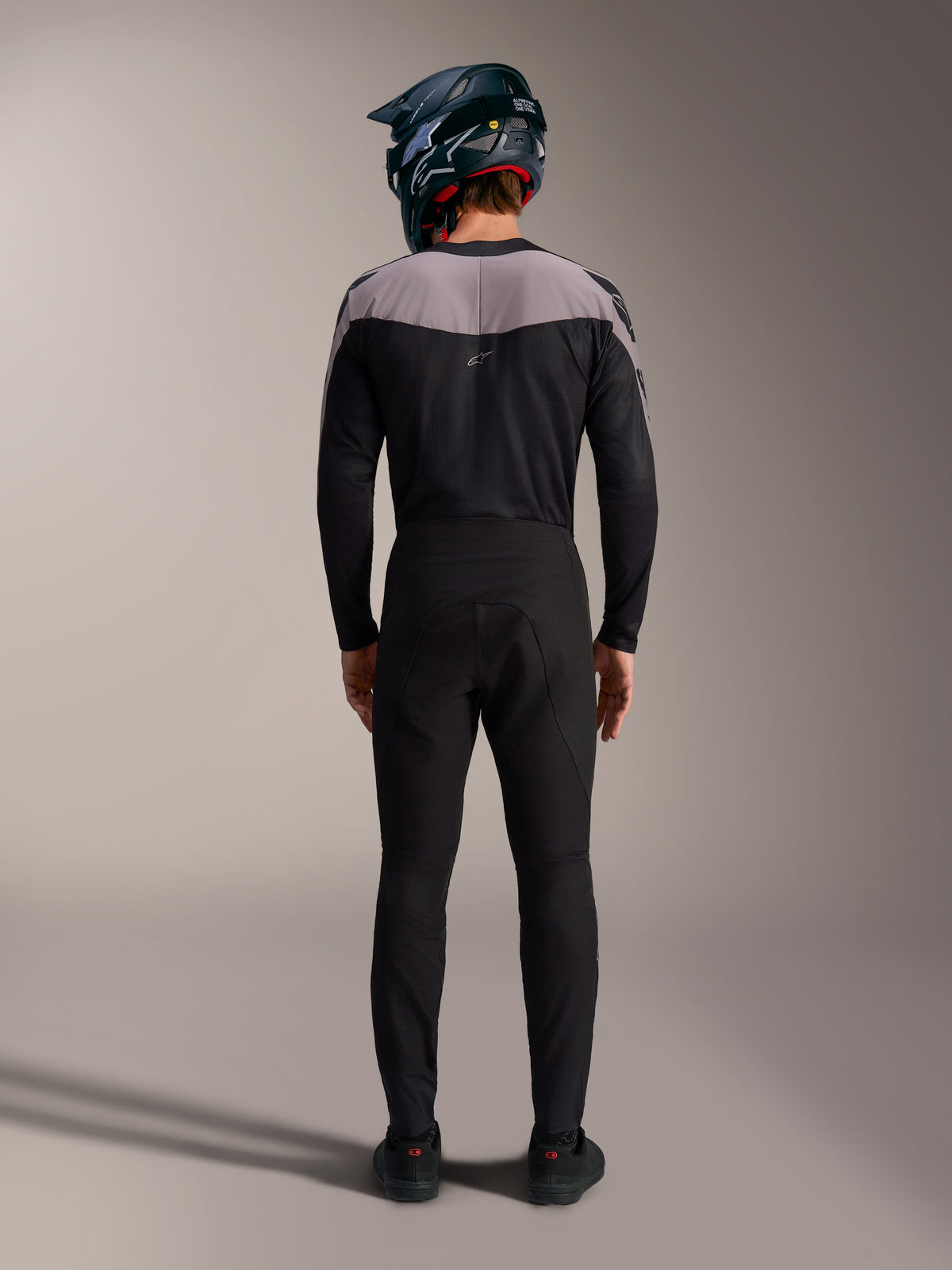 Alpinestars A-Supra Elite MTB-sæt i sort med bukser, trøje og full-face hjelm, set bagfra.