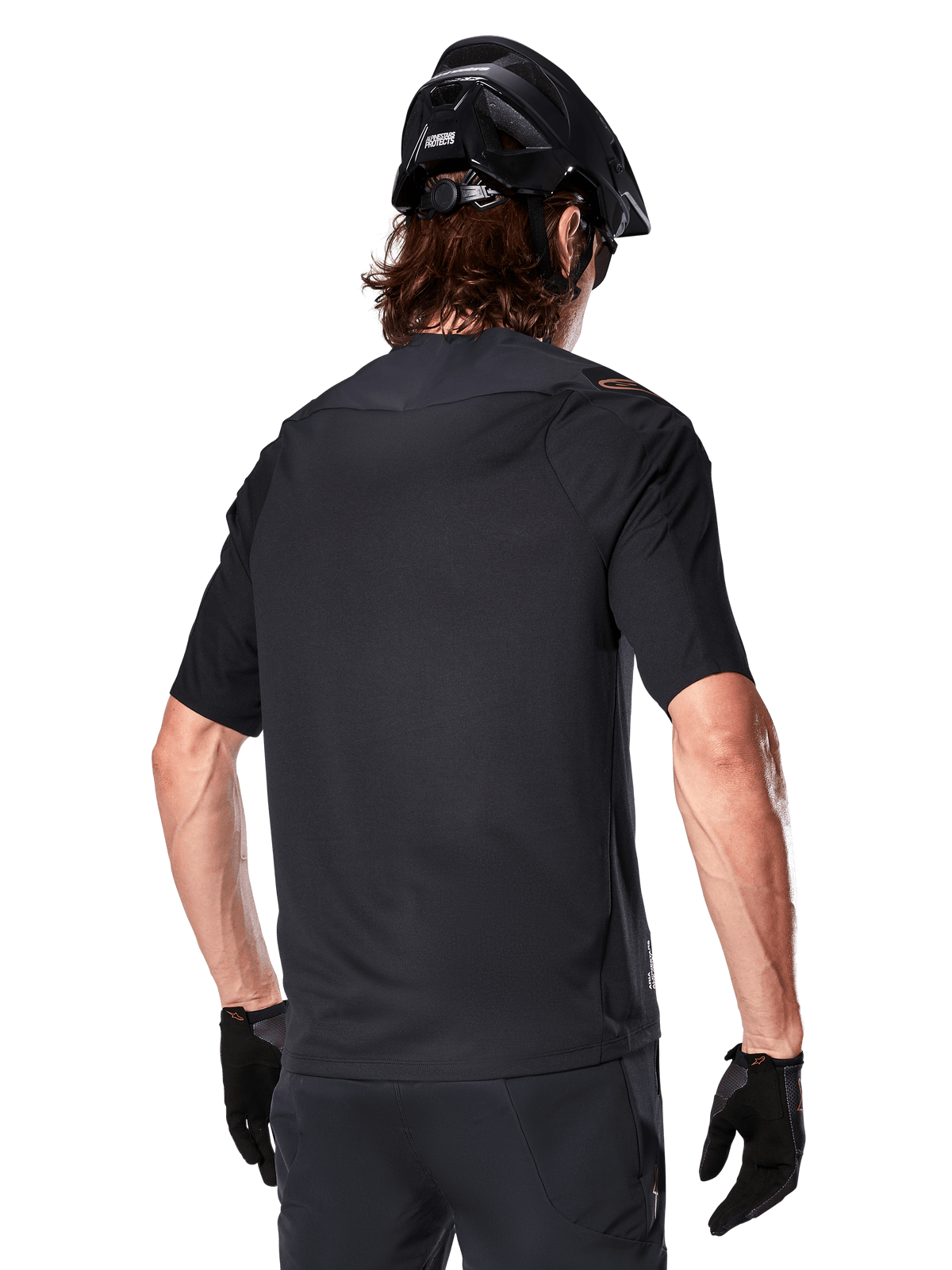 Alpinestars A-Aria Polartec Switch kortærmet trøje, sort, set bagfra på en rytter med sort mountainbikehjelm, matchende sorte shorts og handsker, performance-udstyr til mountainbiking