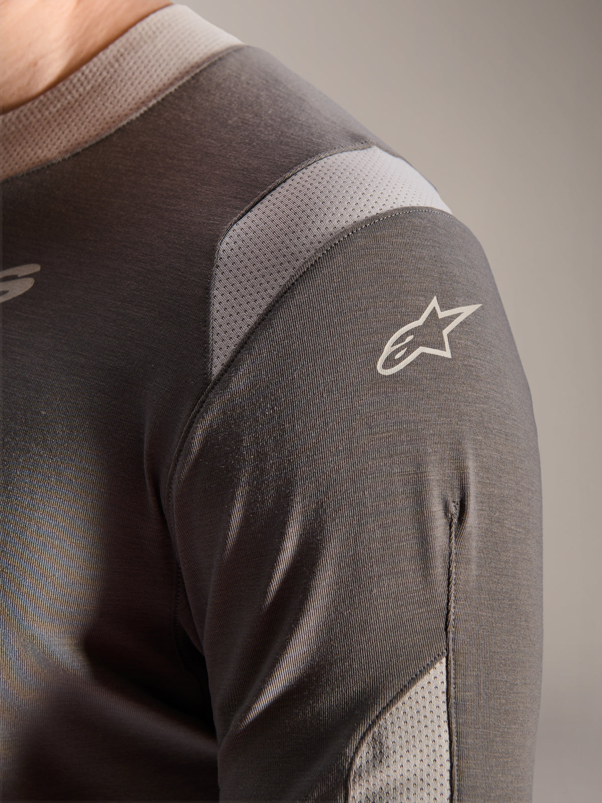 Alpinestars A-Dura Dri Wool Jersey - Long Sleeve, Dark Gray, detailed view of the shoulder and sleeve showing light gray mesh ventilation panels and the white Astars logo on the technical drirelease fabric.