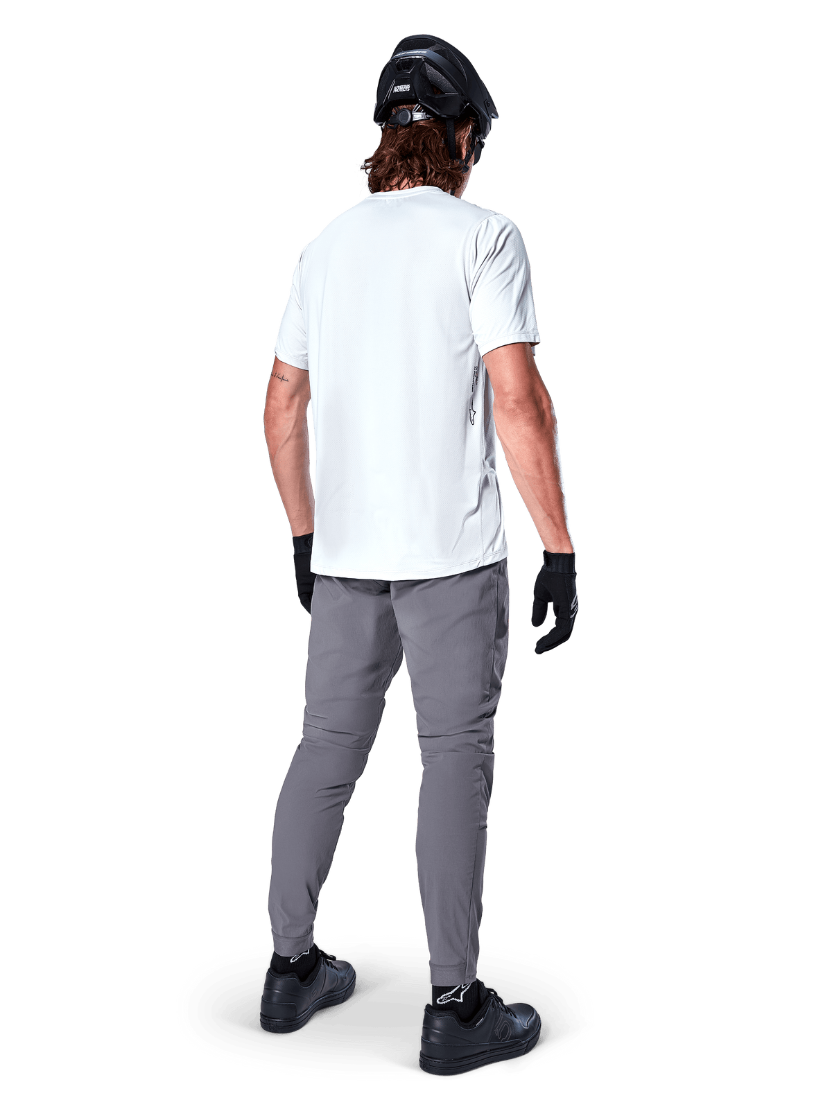 Alpinestars A-Dura Oscar kortærmet jersey i White Dove, set bagfra båret af en rytter med grå cykelbukser, sort hjelm og handsker, teknisk mountainbike-tøj til off-road terrænkørsel