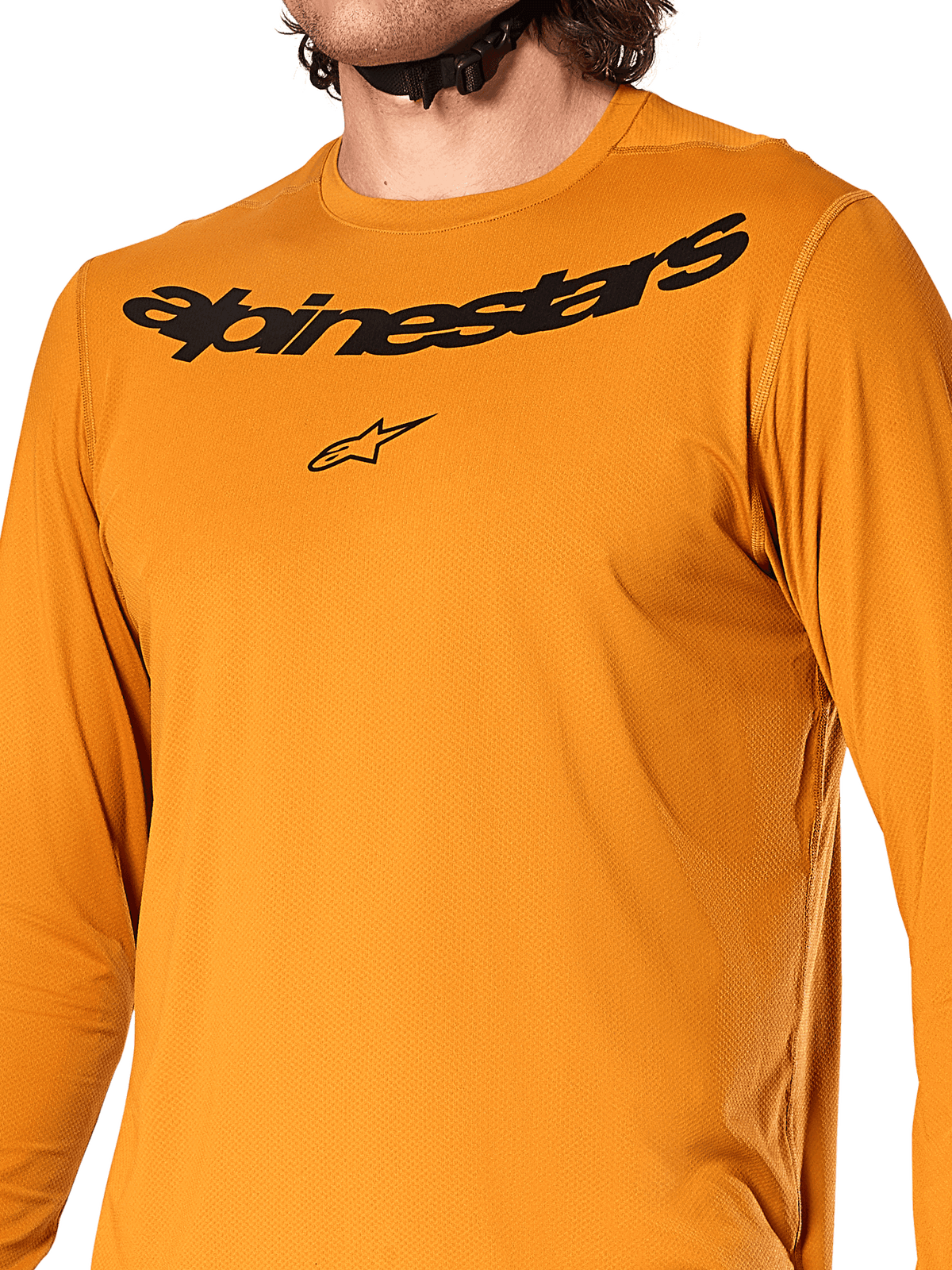 Alpinestars A-Dura Rocker langærmet trøje, mørk guld, nærbillede af brystet med sort Alpinestars tekstlogo og stjernelogo, tekstureret jacquard fugttransporterende materiale, performance MTB-cykeltøj