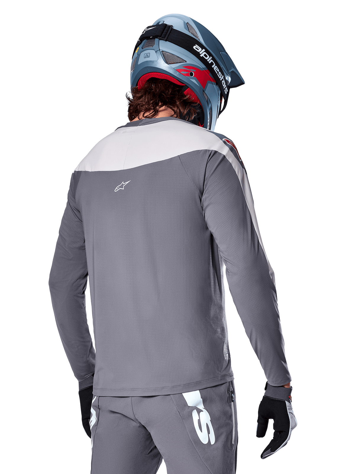 Alpinestars A-Supra Race Jersey, langærmet MTB-trøje i mørkegrå og lysegrå, set bagfra viser performance-pasform og Astar-logo, matchende grå bukser og blå mountainbike-hjelm, designet til off-road mountainbiking