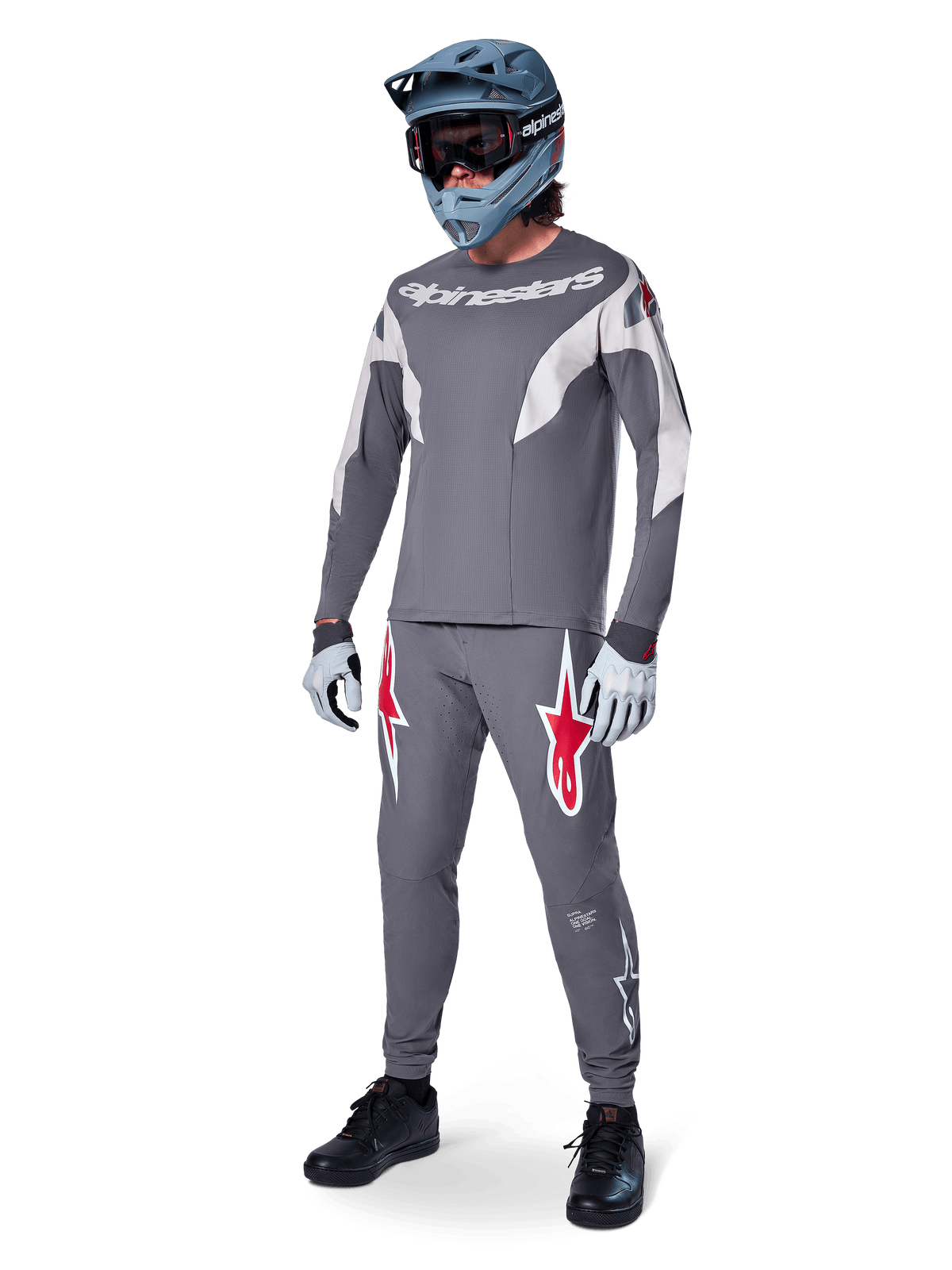 Alpinestars A-Supra Race langærmet jersey, MTB-rytter, mørkegrå med lysegrå detaljer, matchende mørkegrå bukser med rødt stjernelogo, grå full-face hjelm med goggles, lysegrå handsker, koordineret mountainbike-outfit til racing