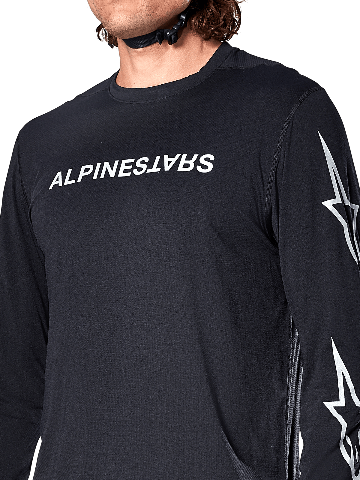 Alpinestars A-Dura Switch langærmet trøje, sort, med hvidt Alpinestars-navnetræk på brystet og stjernelogoer på ærmet, båret af en rytter med synlig hjelmrem, teknisk mountainbike-beklædning.