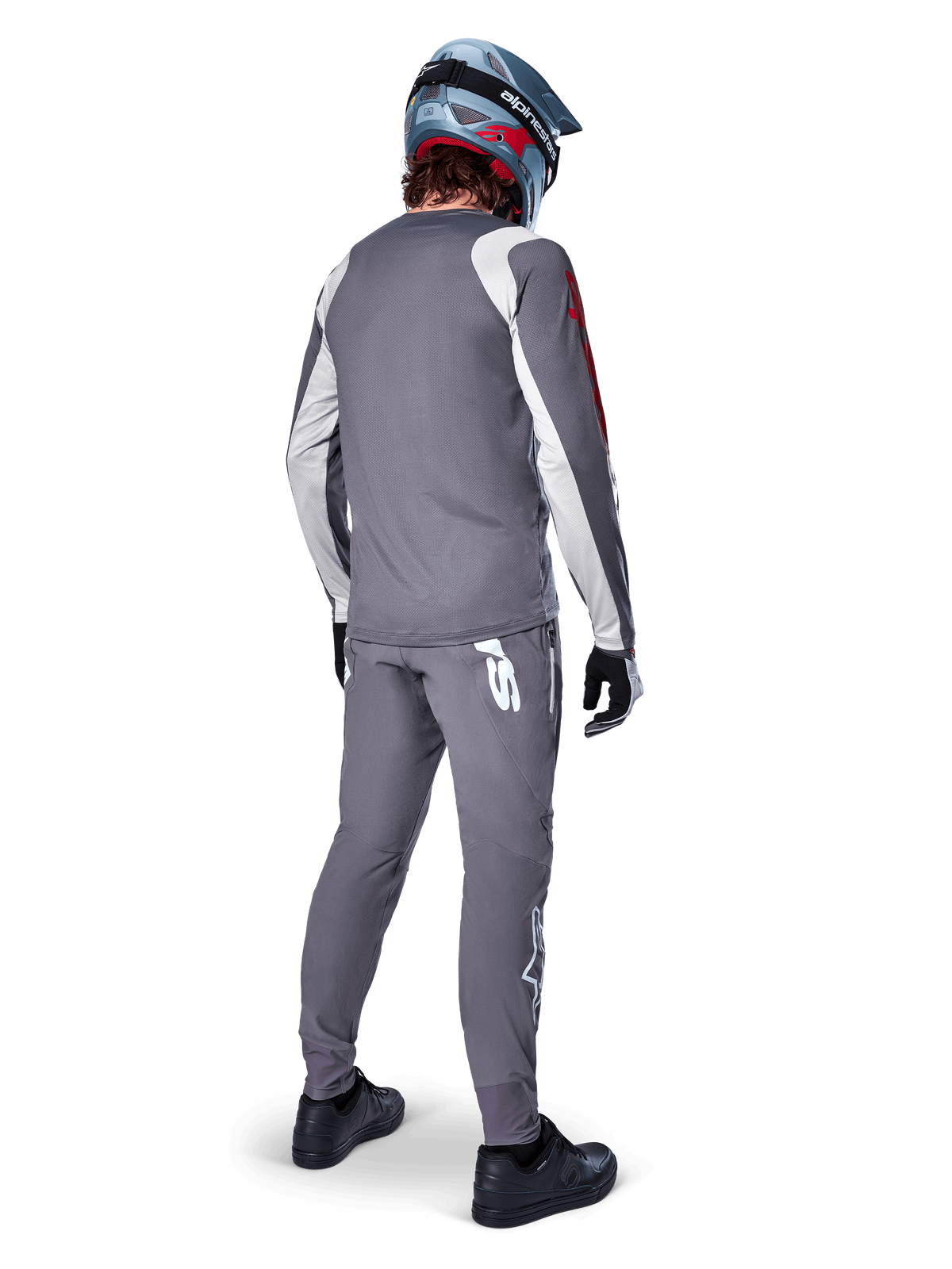 Alpinestars A-Supra Astar Jersey, Long Sleeve MTB Jersey, Dark Gray with white sleeve accents and red logo, back view of rider wearing matching gray pants and blue full-face helmet, performance cycling apparel
