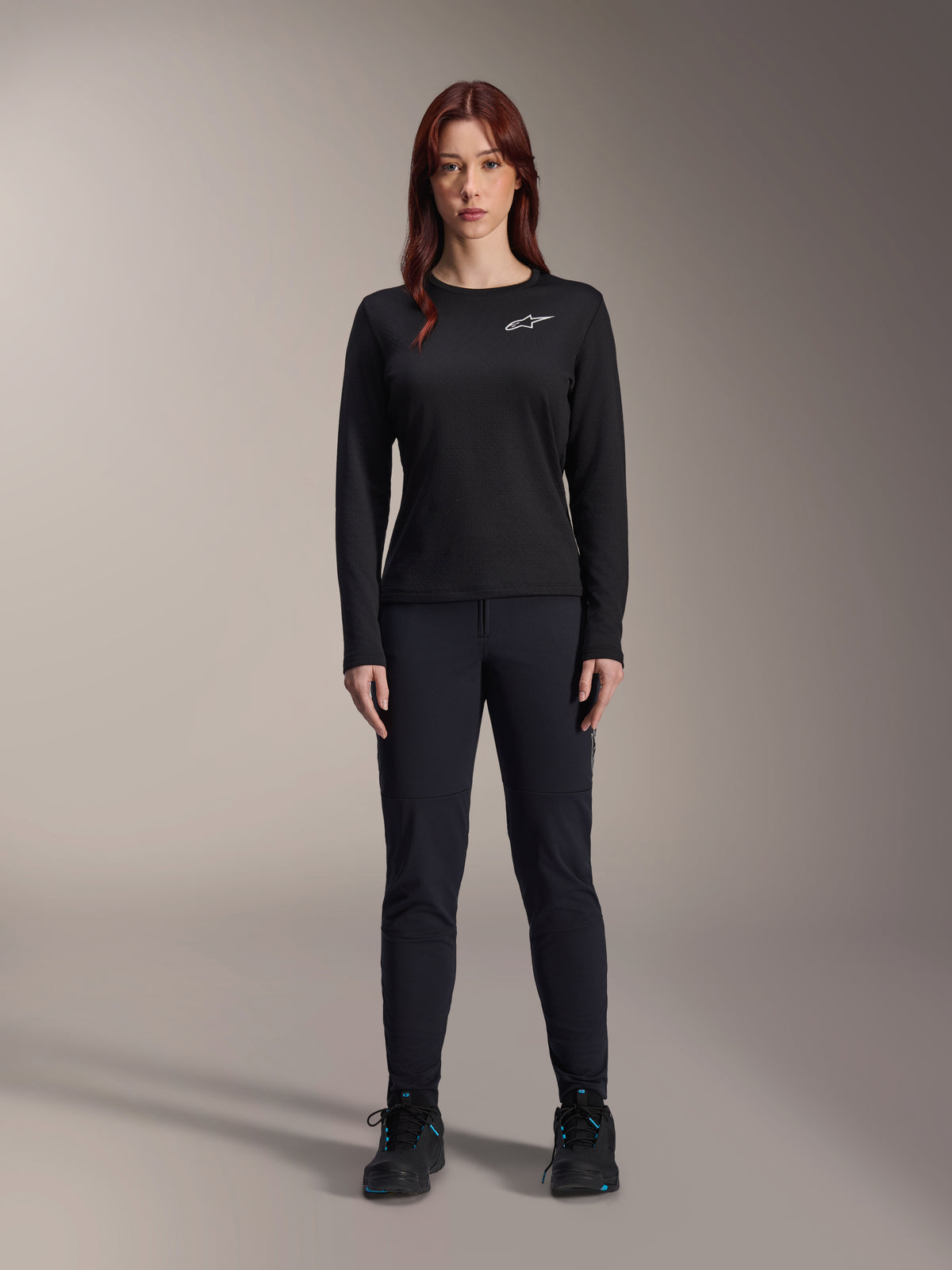 Alpinestars Stella A-Dura Thermal trøje, langærmet mountainbike-trøje til kvinder i sort, med hvidt brystlogo, kombineret med matchende sort udstyr og cykelsko, studioportræt.