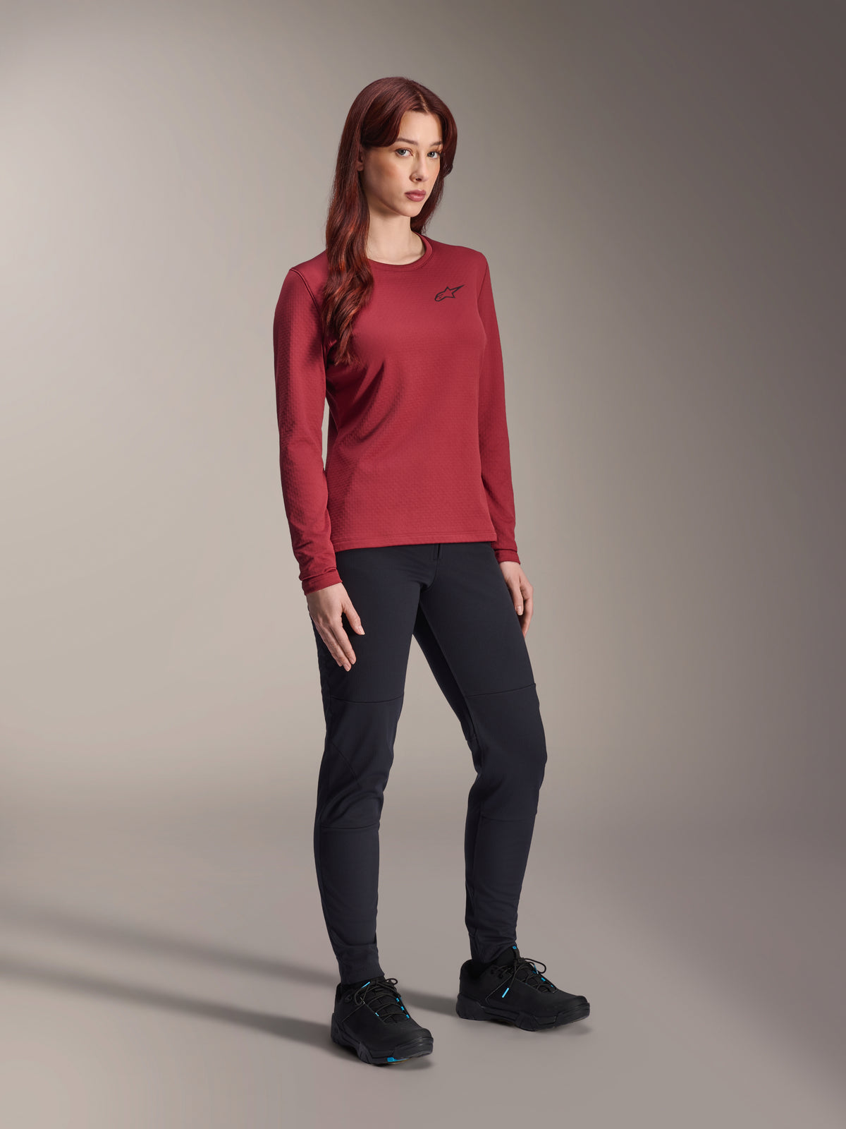 Alpinestars Stella A-Dura Termotrøje, langærmet mountainbike-trøje til damer, bordeaux, kombineret med sorte bukser og sorte sko, rund hals med lille sort logo på brystet, funktionelt design med regulær pasform til off-road cykling