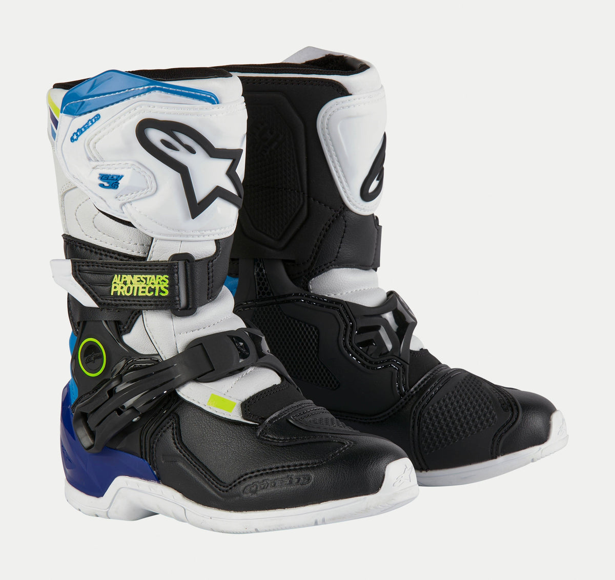 Alpinestars Kids Tech 3S Boots, Youth Motocross Boots, White Black and Enamel Blue, featuring white and black protective panels, blue accents on the heel and top, neon yellow branding, and a secure buckle closure system.