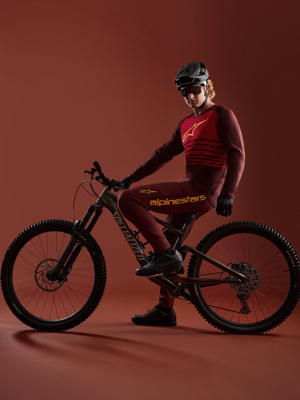 Bordeaux A-Dura Elite trøje 2.0 og bukser på mountainbiker med en Specialized-cykel i et studie.
