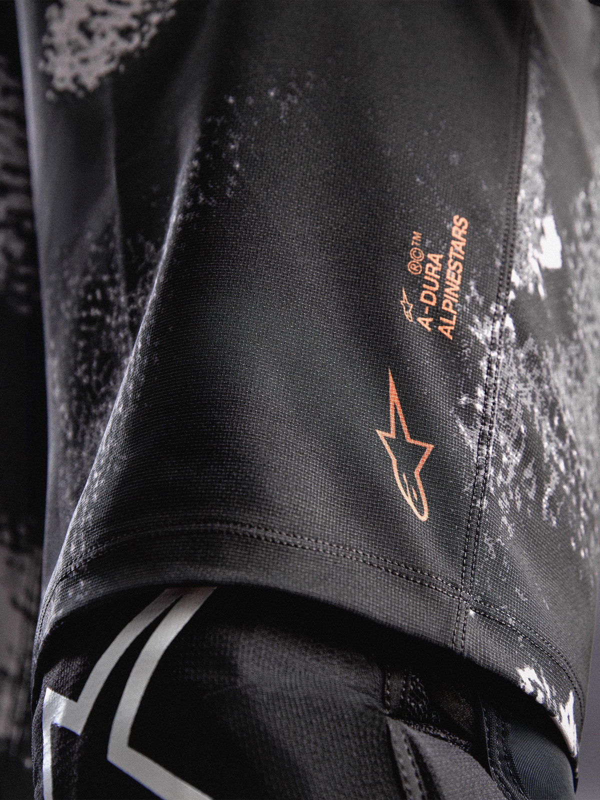 A-Dura Ride Shorts i sort camouflage med orange Alpinestars-logo på holdbart 4-vejs strækstof til MTB.