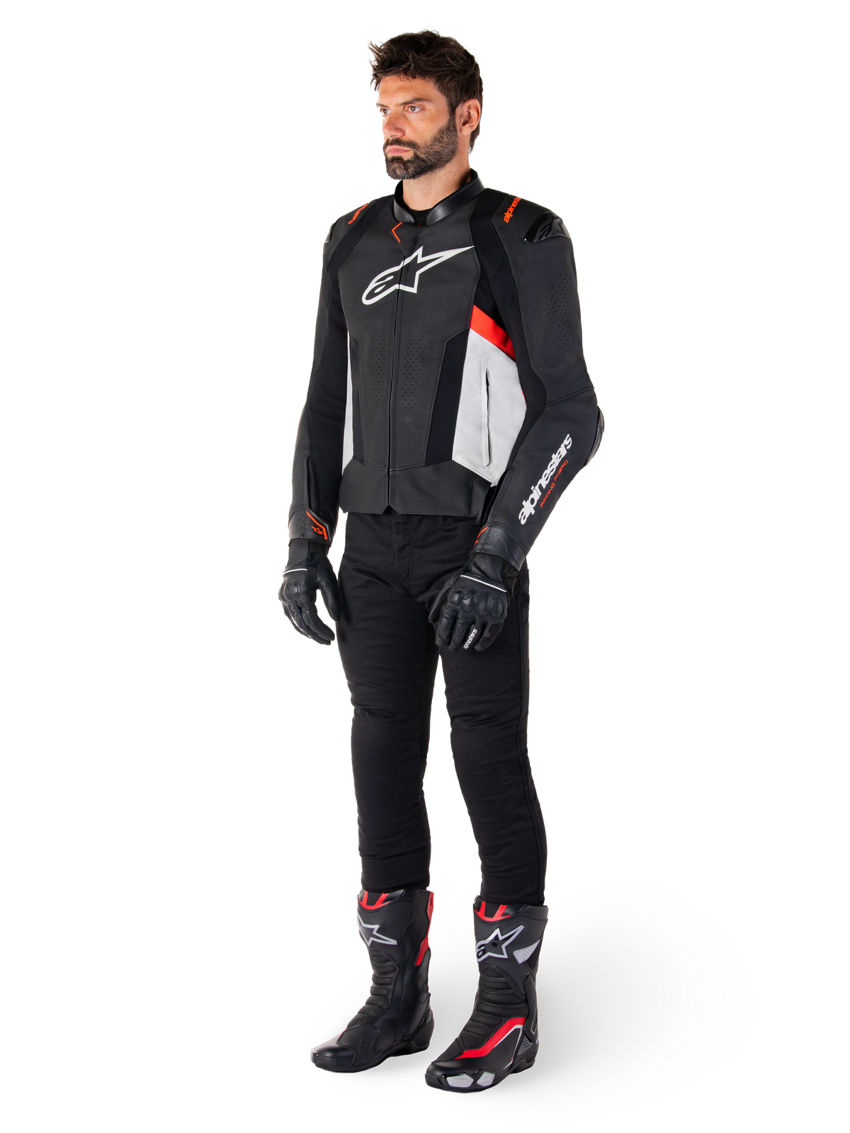 Mandlig model iført Alpinestars Missile V3 læderjakke i sort, hvid og rød fluo, kombineret med sorte motorcykelbukser, handsker og støvler, konstruktion i premium bovinlæder med tydelig Alpinestars-branding, professionel racing-sport-æstetik
