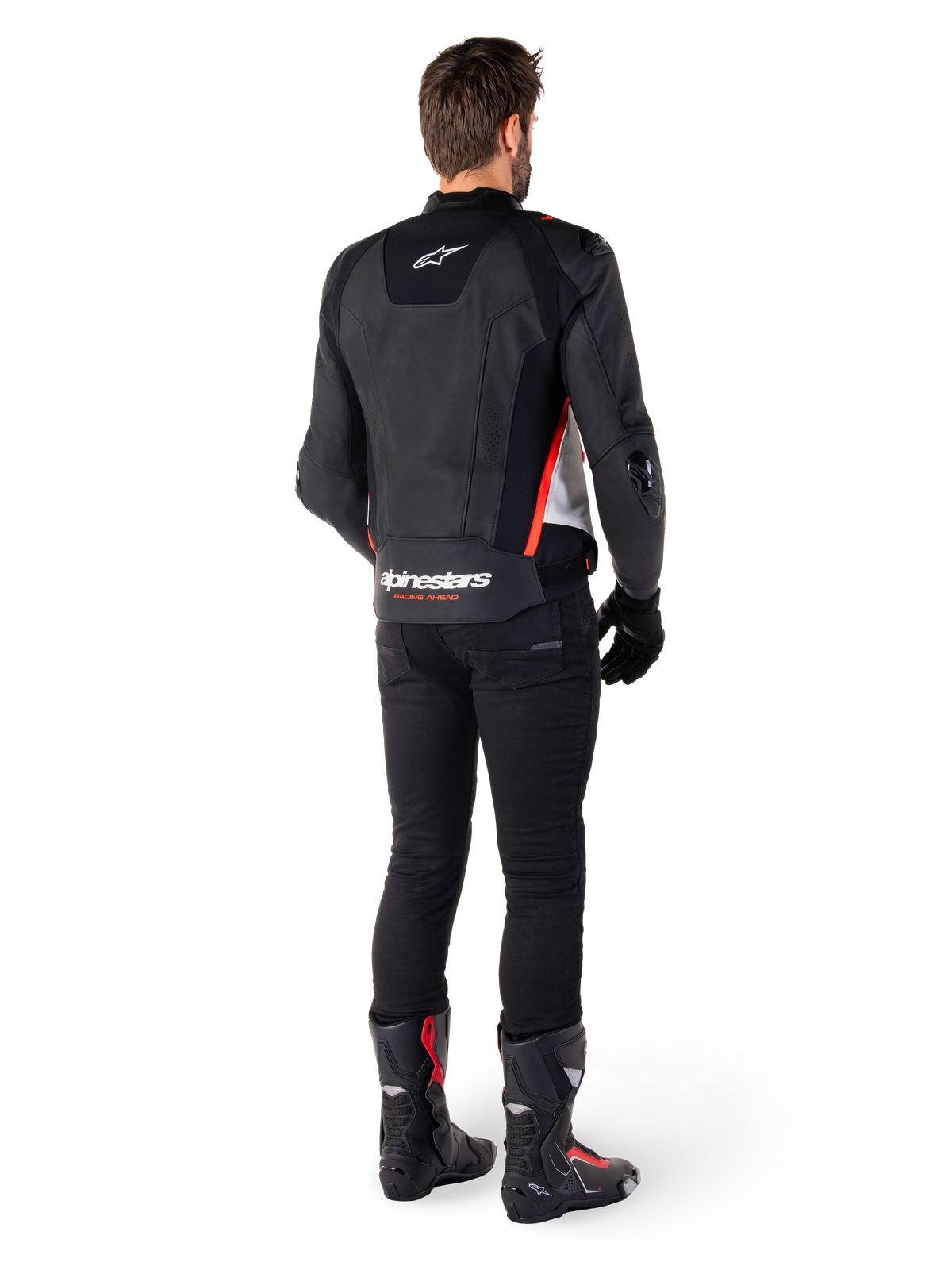 Alpinestars Missile V3 læderjakke i Sort Hvid Rød Fluo, set bagfra på en mandlig kører, med Alpinestars-branding på øvre og nedre ryg, kombineret med sorte bukser og motorcykelstøvler, racing-inspireret sportslæderjakke.