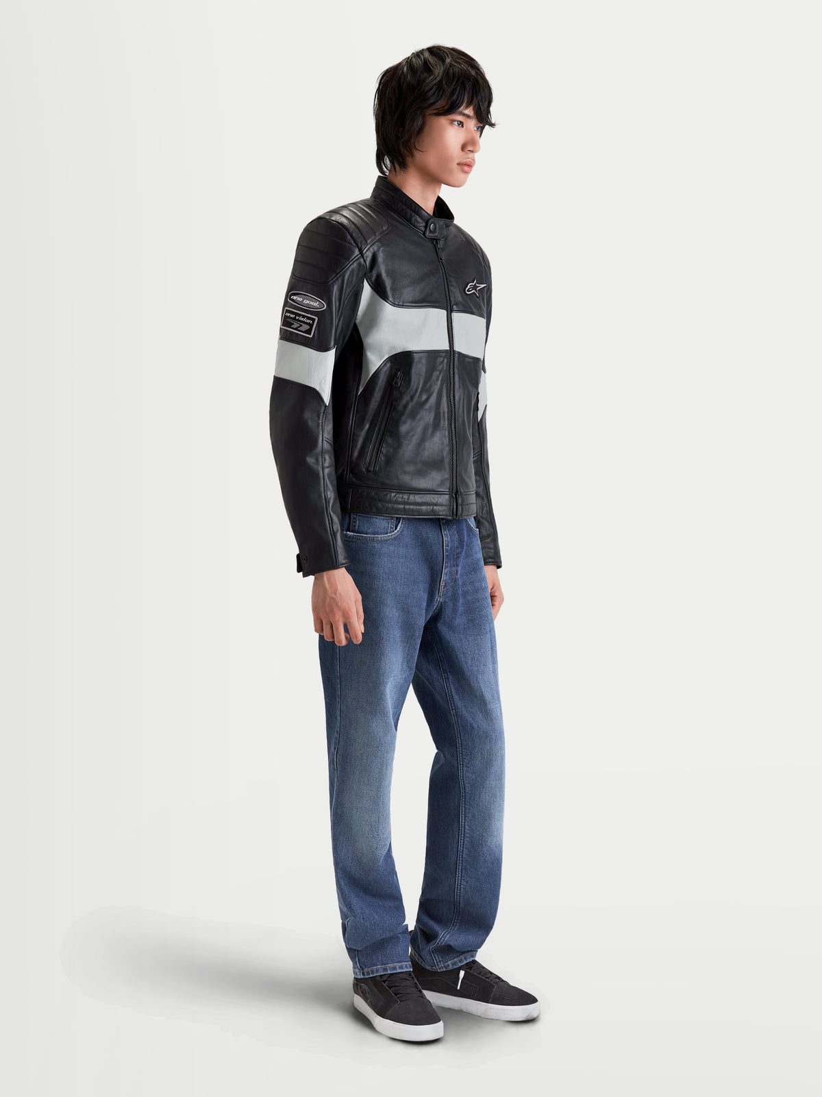 Alpinestars Revern Læderjakke, herre-urbanmotorcykeljakke i sort og grå, sideprofilbillede af model iført jeans, med full-grain læderkonstruktion og vintagestil