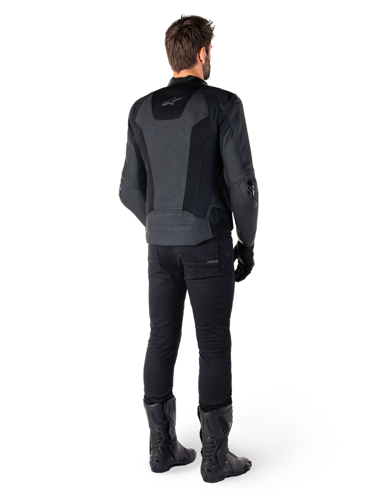 Set bagfra af en mand iført Alpinestars Missile V3 Airflow læderjakke i sort, med omfattende perforerede paneler til ventilation, kombineret med sorte motorcykelbukser og støvler, der fremviser en strømlinet racing-æstetik.