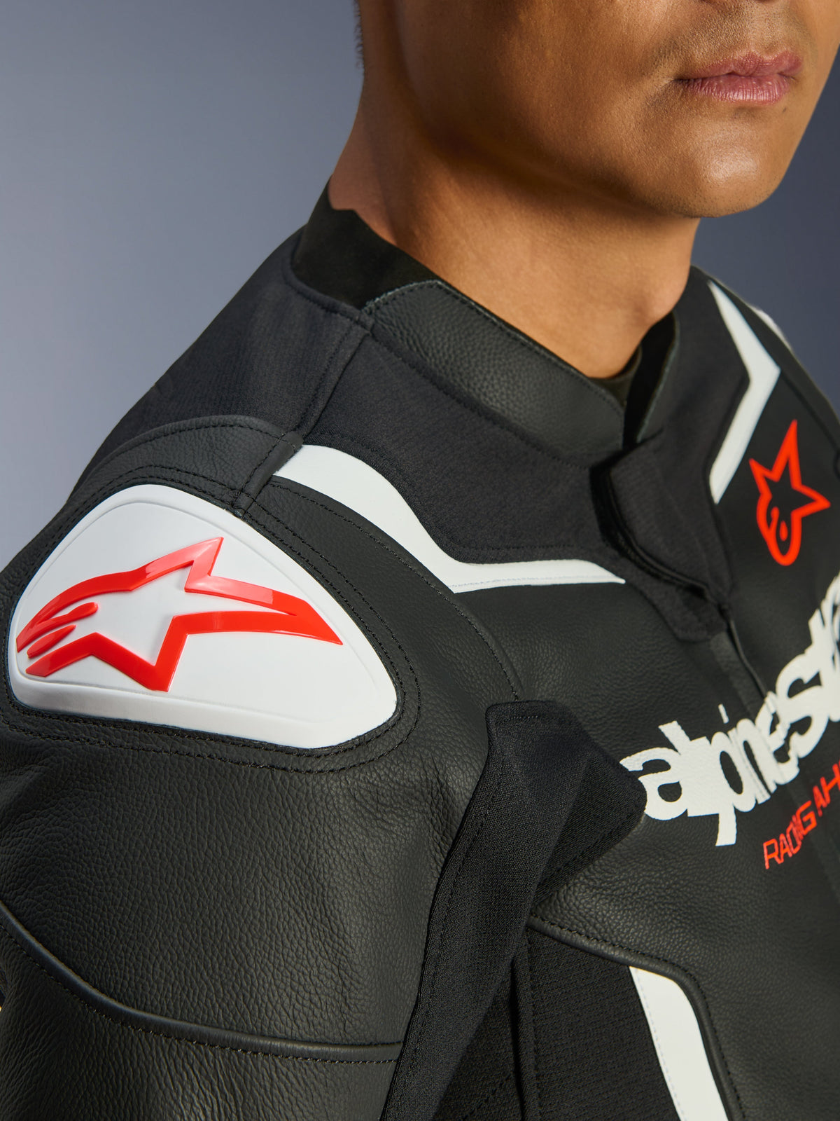 Alpinestars GP Force V2 læderjakke, sort og hvid, nærbillede af GP Lite Evo DFS-skulderbeskytter med rødt Alpinestars-logo, flerpanelkonstruktion i premium okselæder, integrerede strækpaneler til sportskørsel