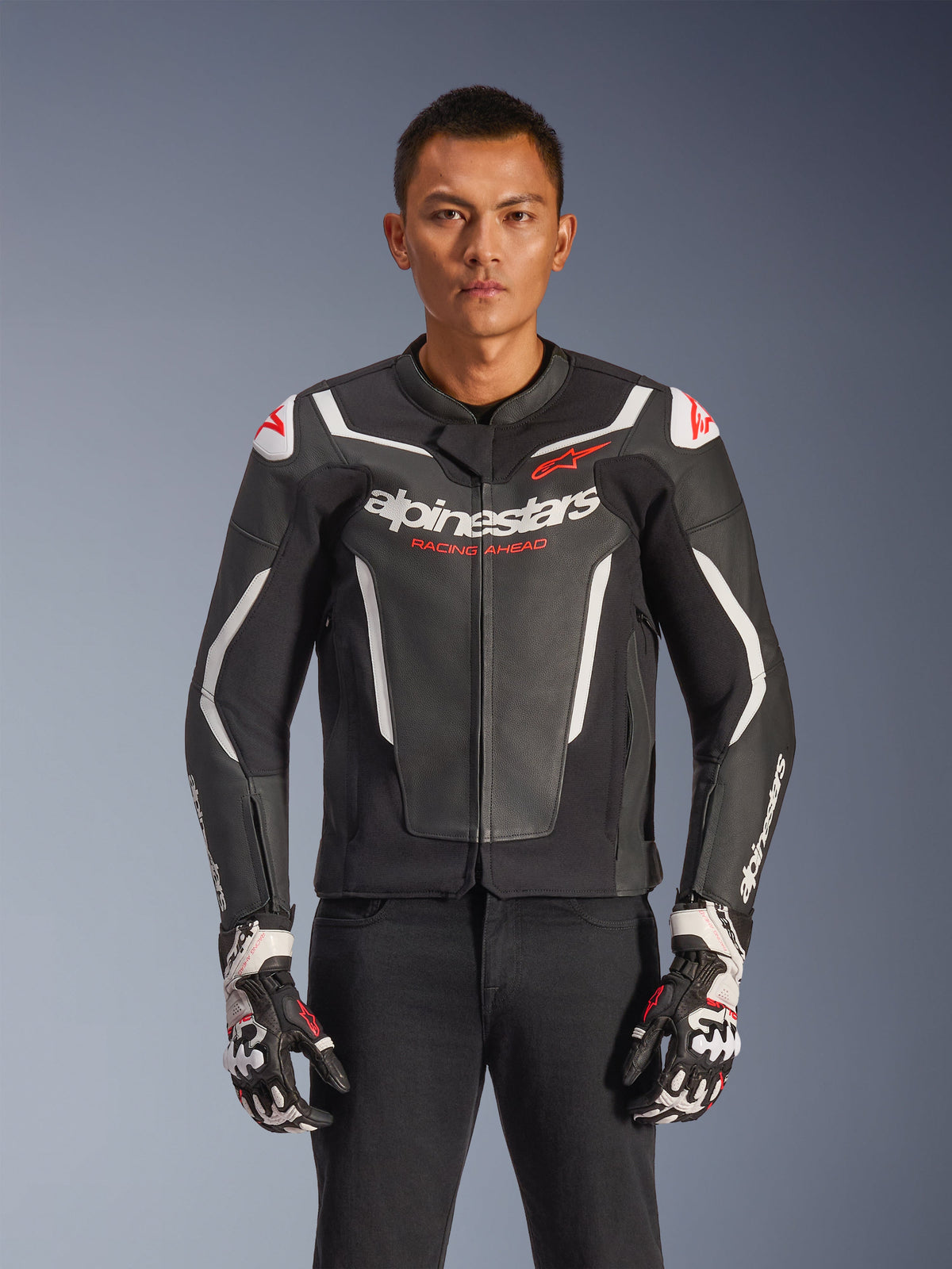 Alpinestars GP Force V2 læderjakke, sort og hvid med røde detaljer, motorcykelracingjakke, premium læderkonstruktion med beskyttelse, Racing Ahead-branding, båret med matchende handsker