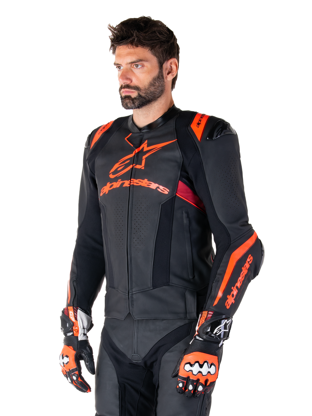 Alpinestars Missile V3 Ignition Leather Jacket, Black with Red Fluo and Dark Red accents, worn by a male model with matching racing gloves and leather pants, featuring bold Alpinestars branding, perforated leather panels, and external shoulder protectors, professional motorcycle racing gear