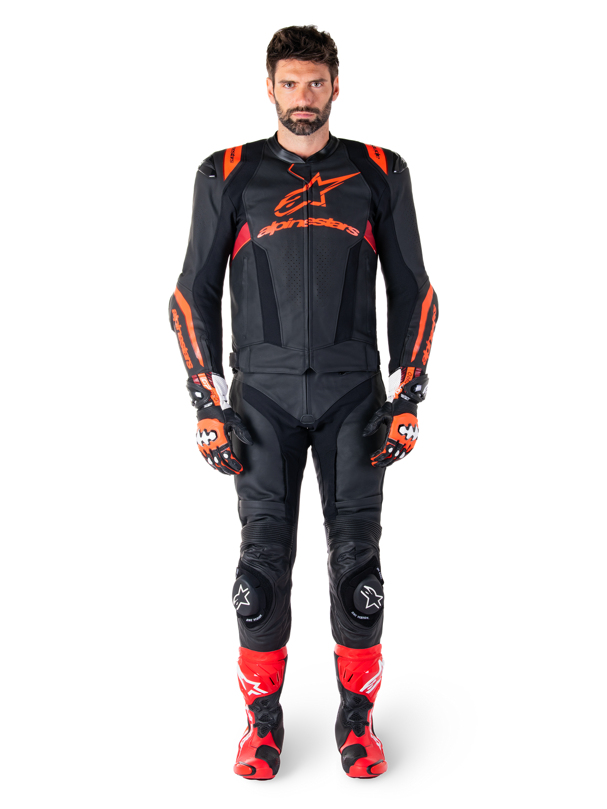 Male model wearing Alpinestars Missile V3 Ignition Leather Jacket in Black Red Fluo Dark Red, complete motorcycle racing gear including matching leather pants, racing gloves, and boots, featuring bold Alpinestars branding on the chest, forward-facing pose, professional sport riding outfit