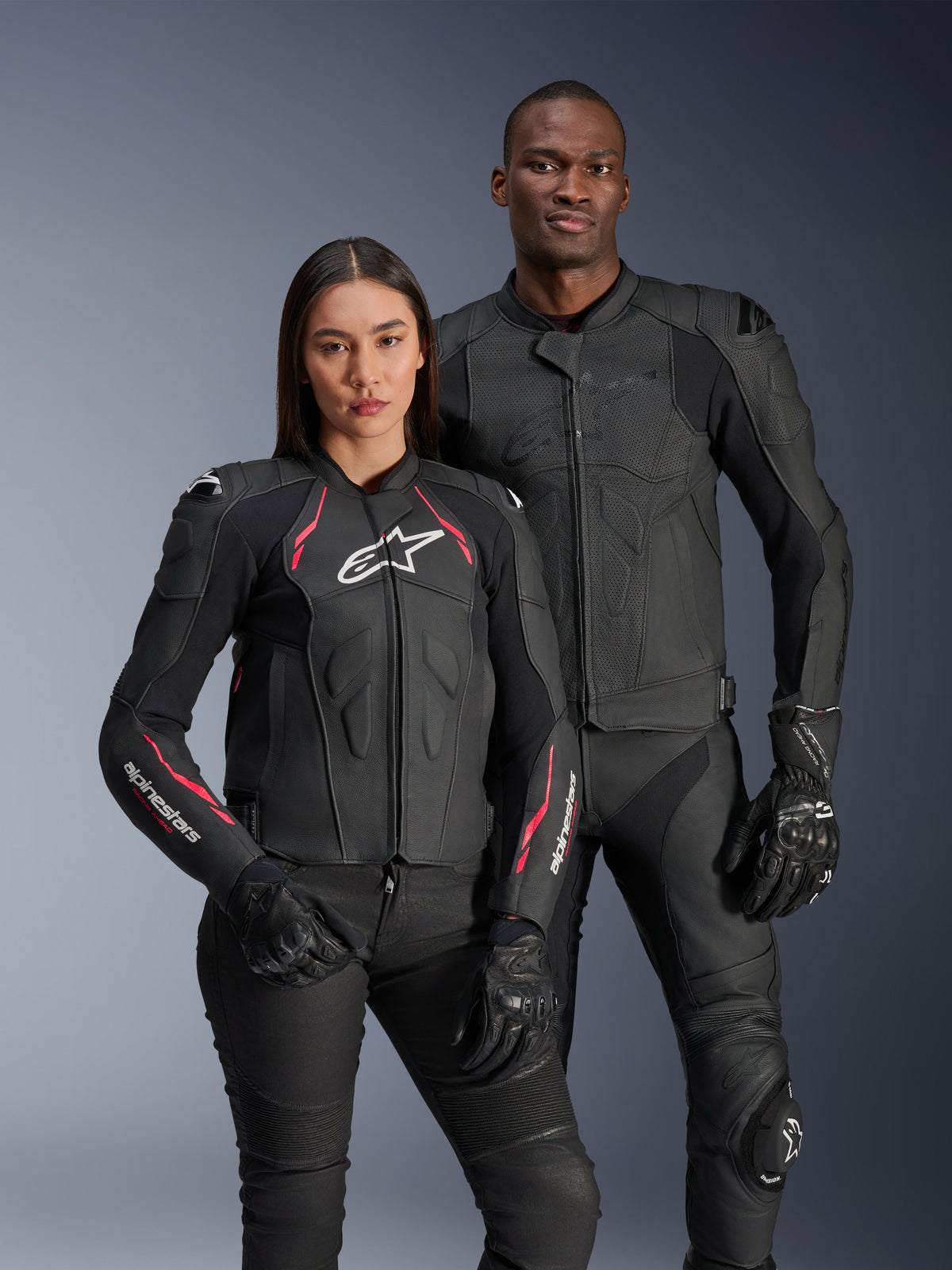 Alpinestars Dusk Airflow og Stella Dusk læderjakker, mandlig og kvindelig kører i sorte lædermotorcykeljakker, herrejakke med perforeret læder for ventilation, damejakke med røde detaljer og hvide logoer, koordineret med sorte kørebukser og handsker, performance sportskørselsudstyr
