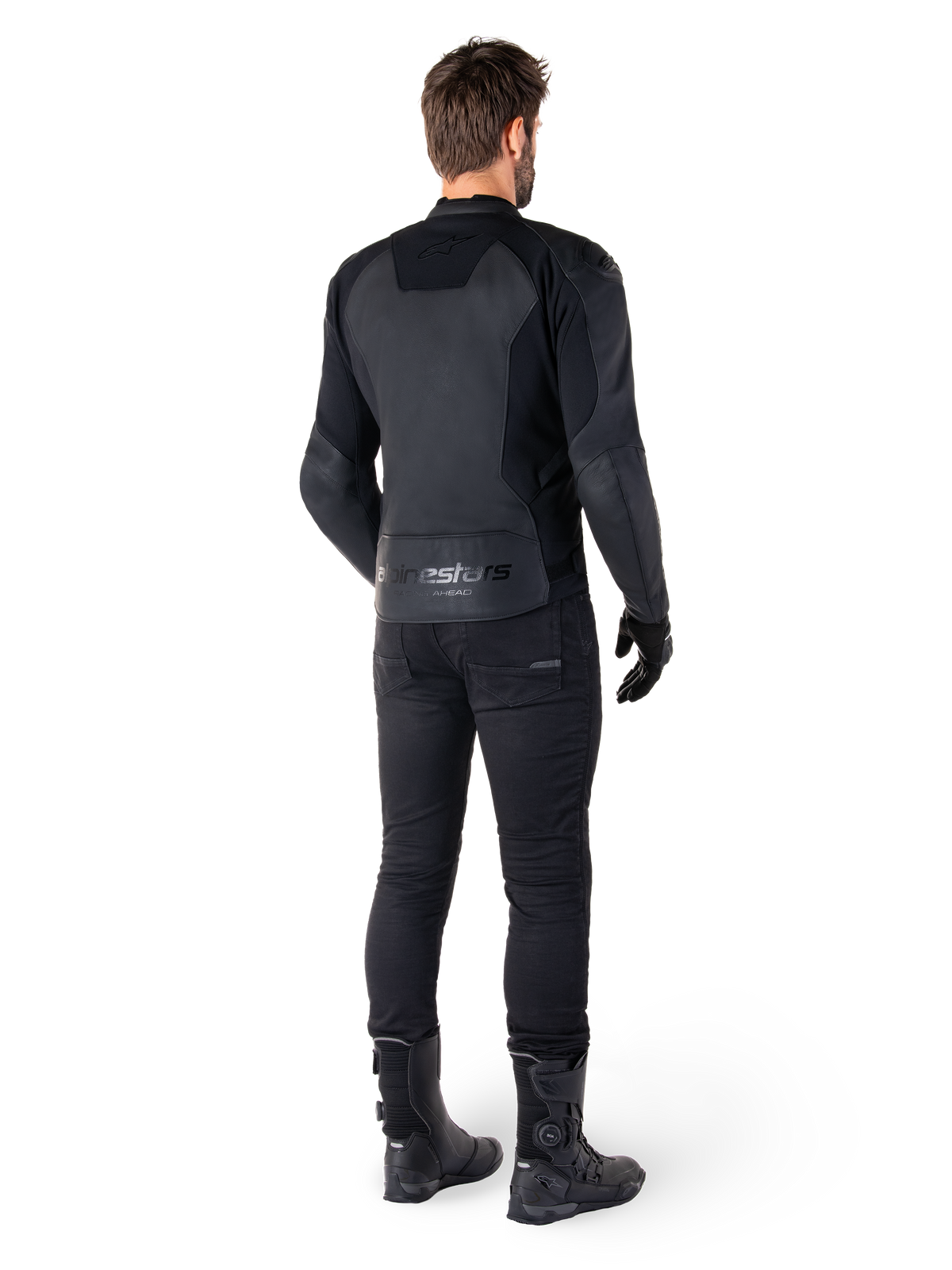 Alpinestars Faster V3 læderjakke, sort, set bagfra på en motorcyklist, med premium læderpaneler og præget Alpinestars-branding, kombineret med sorte kørebukser og støvler for et komplet sportsmotorcykel-look.