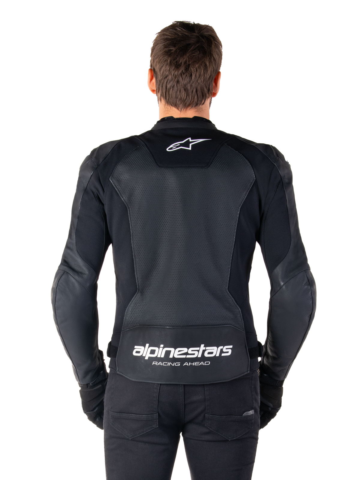 Alpinestars Faster V3 Airflow læderjakke, sort og hvid, set bagfra på en rytter, viser det perforerede læderrygpanel for ventilation, hvidt Alpinestars-logo på den øverste ryg og 'RACING AHEAD'-branding på den nederste ryg, sport-fit motorcykeludstyr.