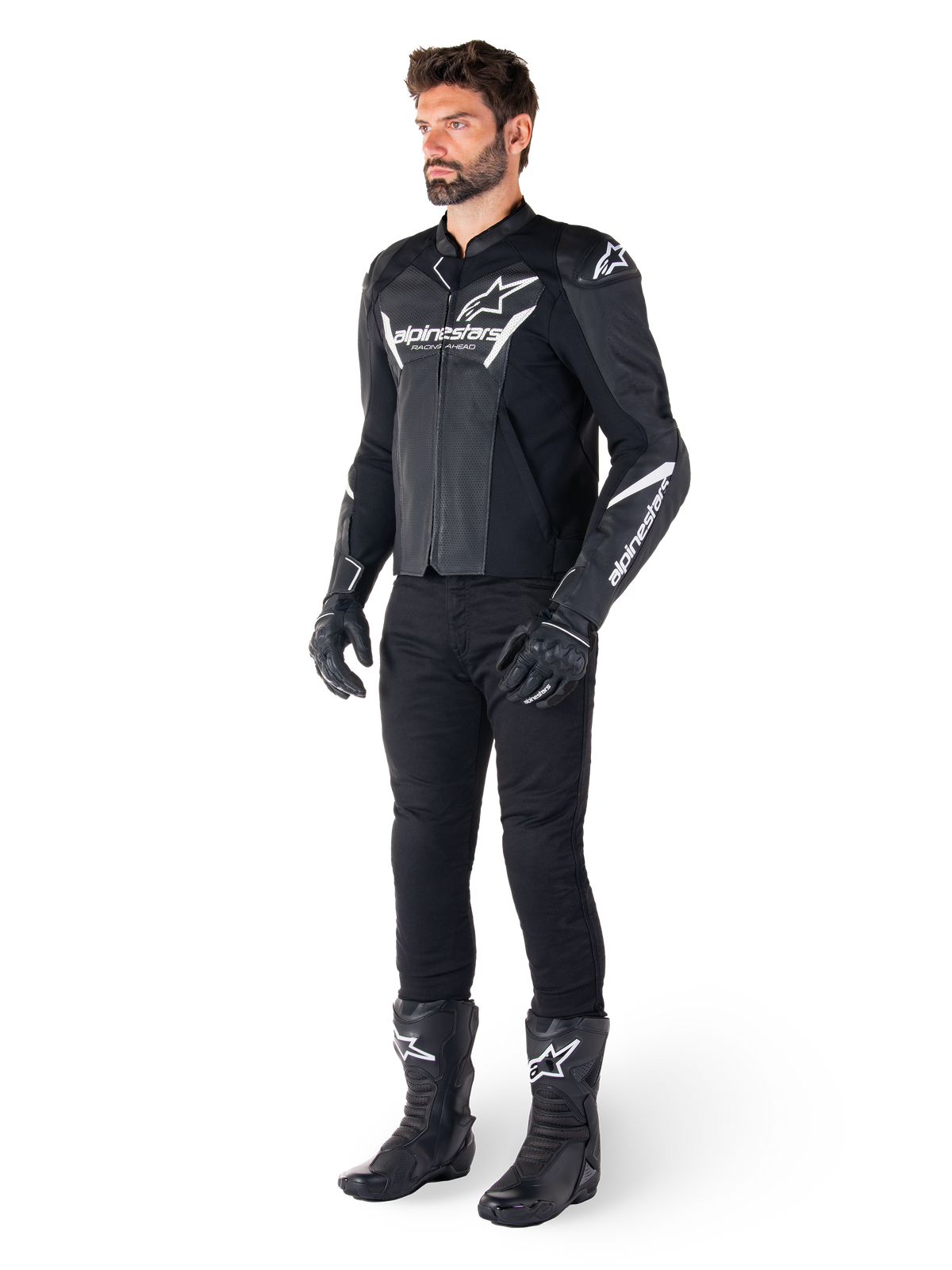 Model wearing Alpinestars Faster V3 Airflow Leather Jacket, Black and White, featuring perforated leather and white Alpinestars logos, paired with black riding pants, gloves, and boots, sport-focused motorcycle gear