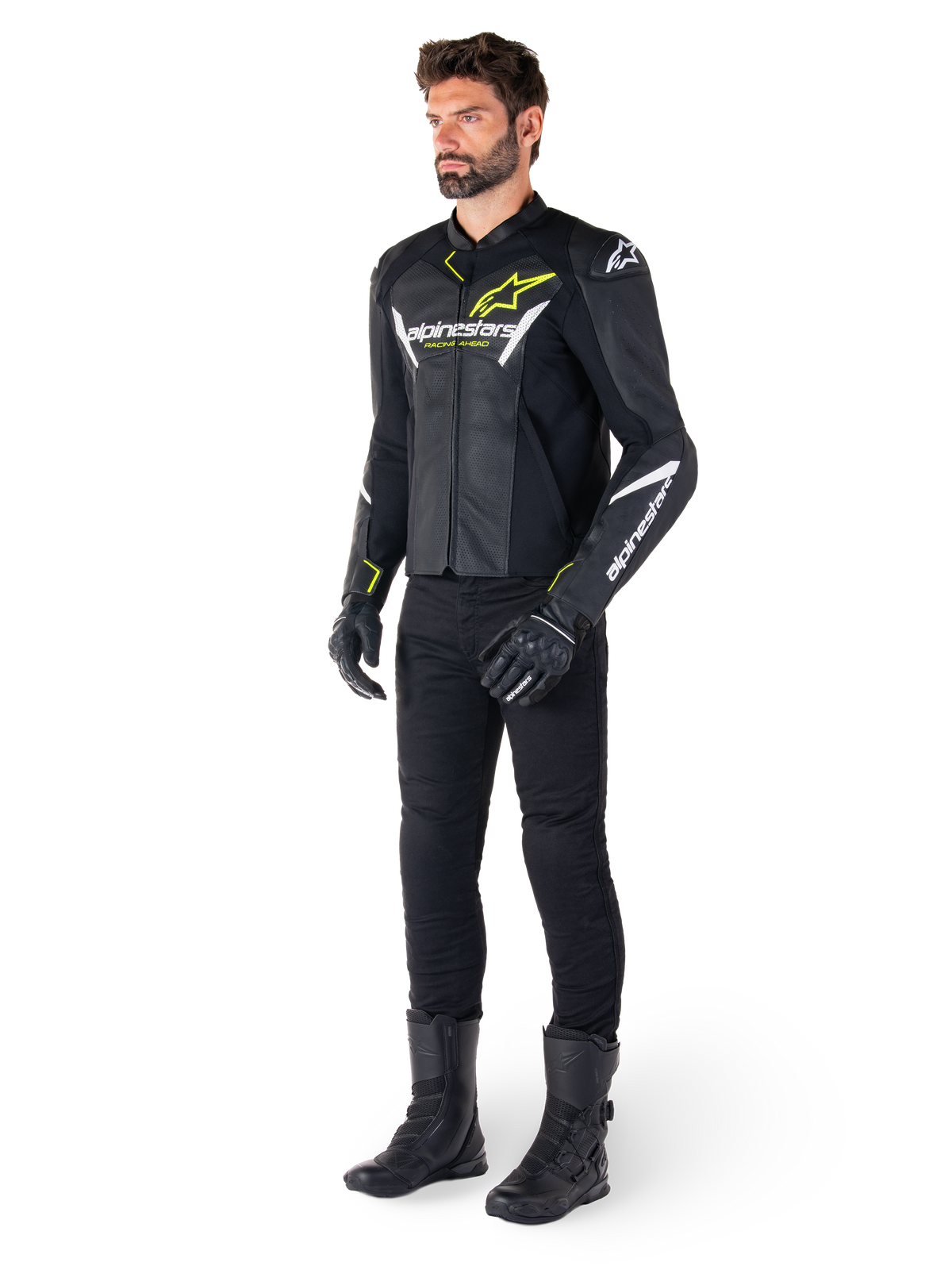 Mandlig rytter iført Alpinestars Faster V3 Airflow læderjakke i sort, hvid og gul fluo, kombineret med sorte motorcykelbukser og støvler, med perforerede læderpaneler, hvide logodetaljer og neongule accenter, professionelt sportsudstyr til kørsel